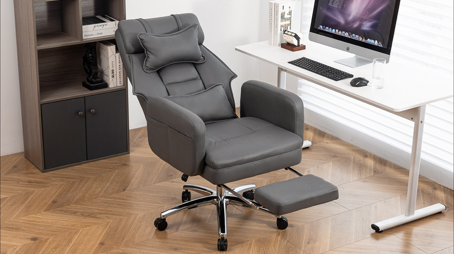 Dark gray faux leather office chair with adjustable footrest and lumbar pillow