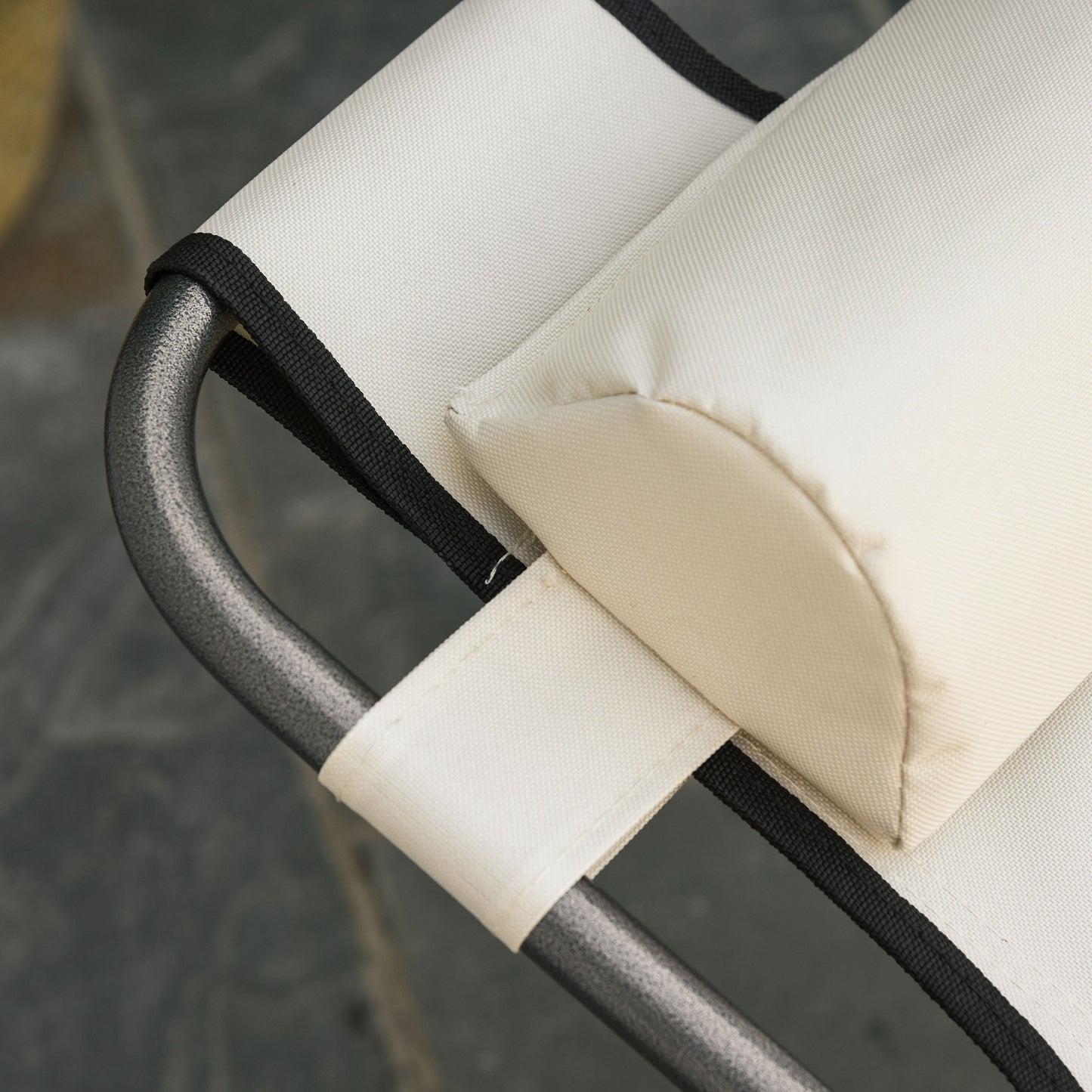 Closeup of a beige canvas chair sling with black trim and a padded headrest