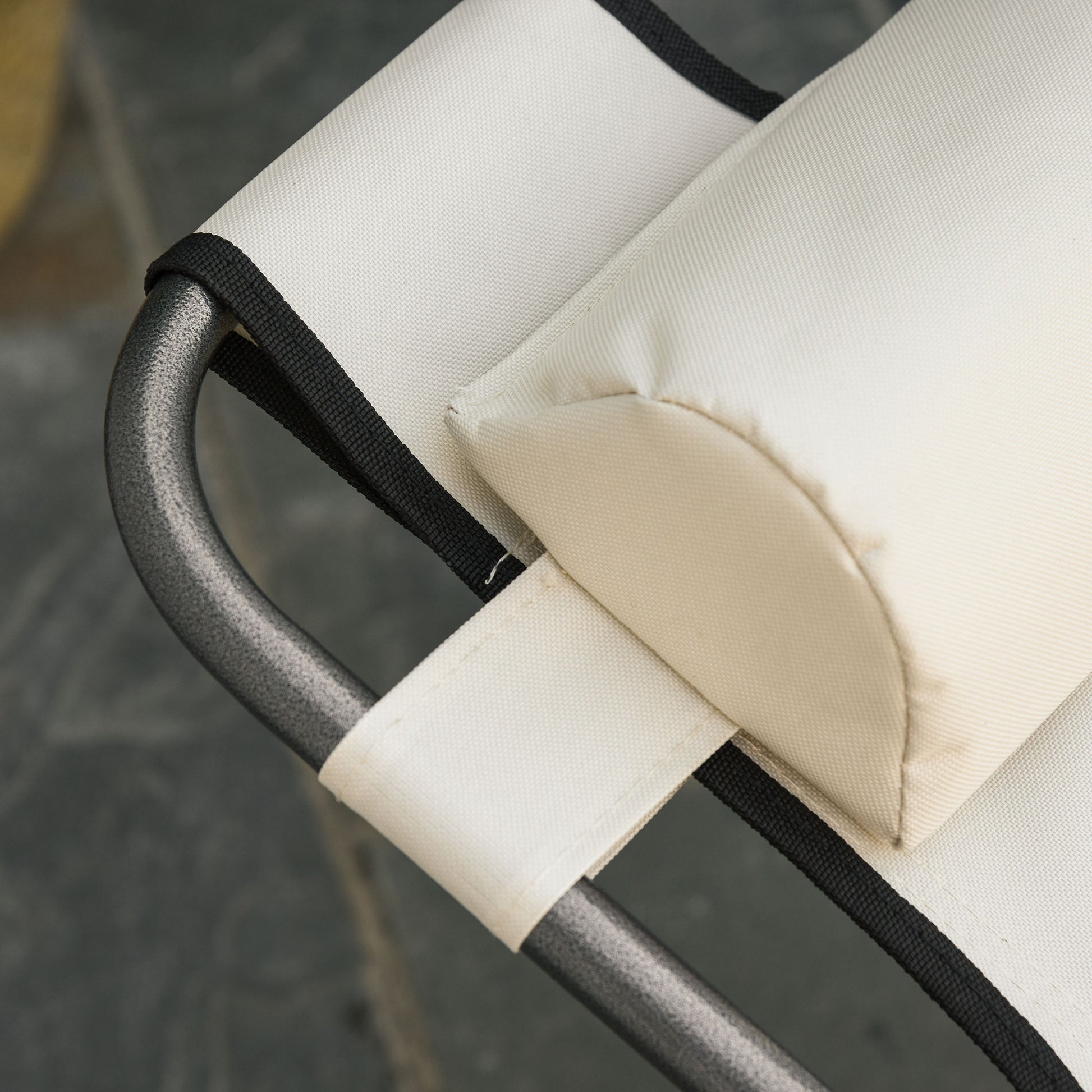 Closeup of a beige canvas chair sling with black trim and a padded headrest