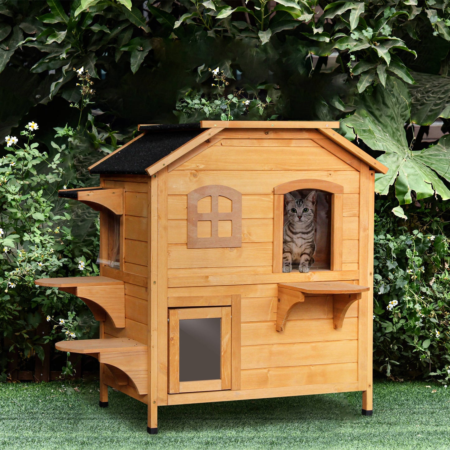 Wooden multilevel outdoor cat house with a tabby cat peeking from a window