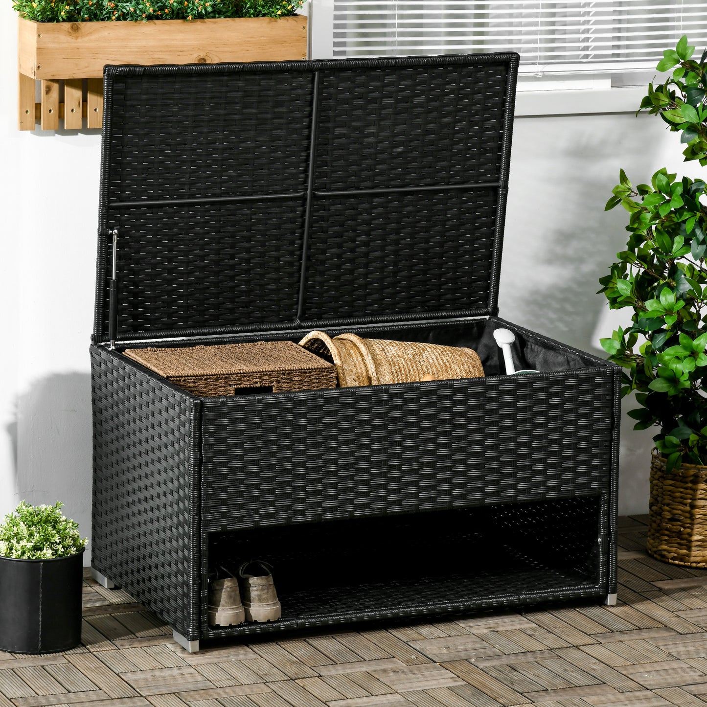 Black wicker outdoor storage bench with lid open showing baskets and shoes