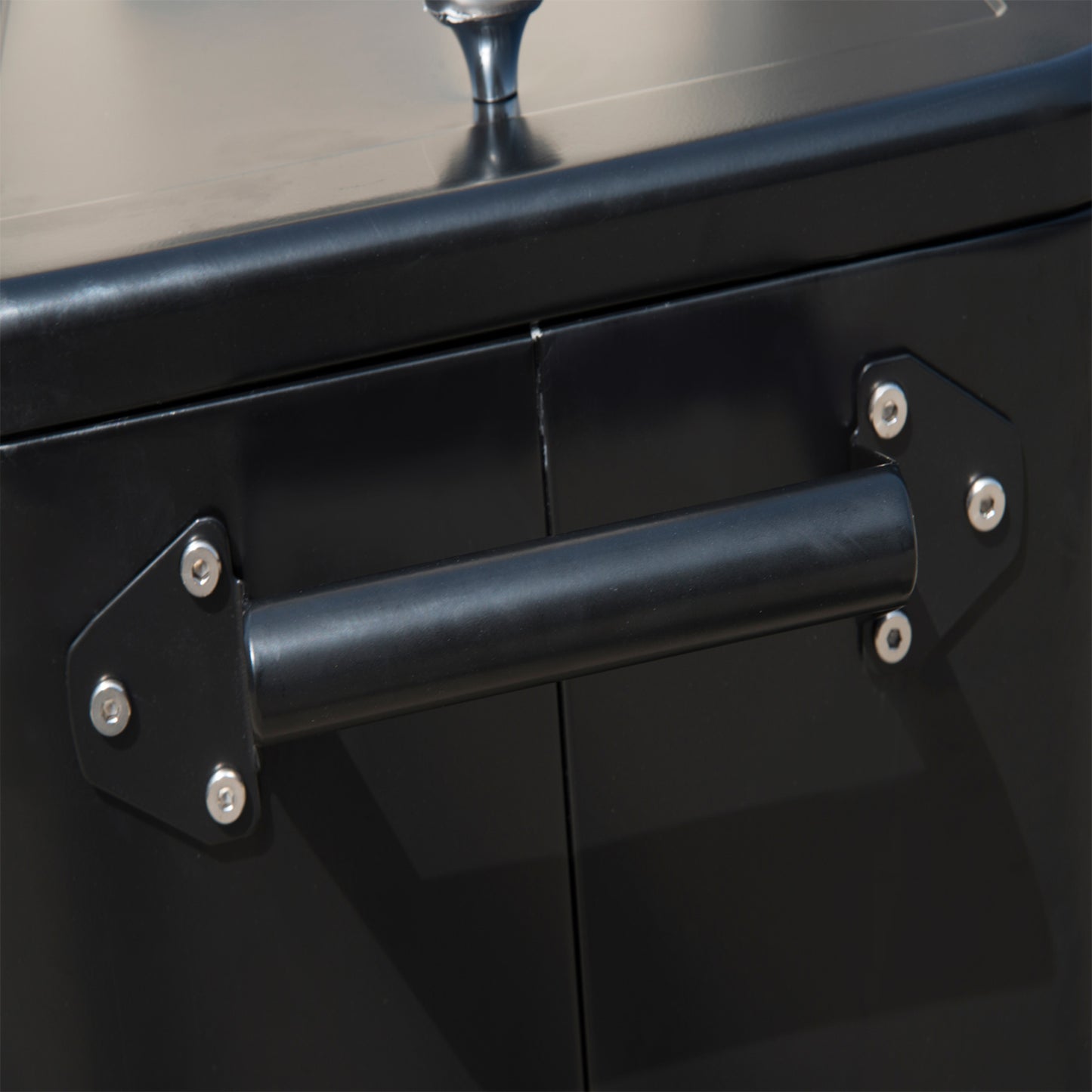 Black metal cooler with a sturdy side handle for easy transport