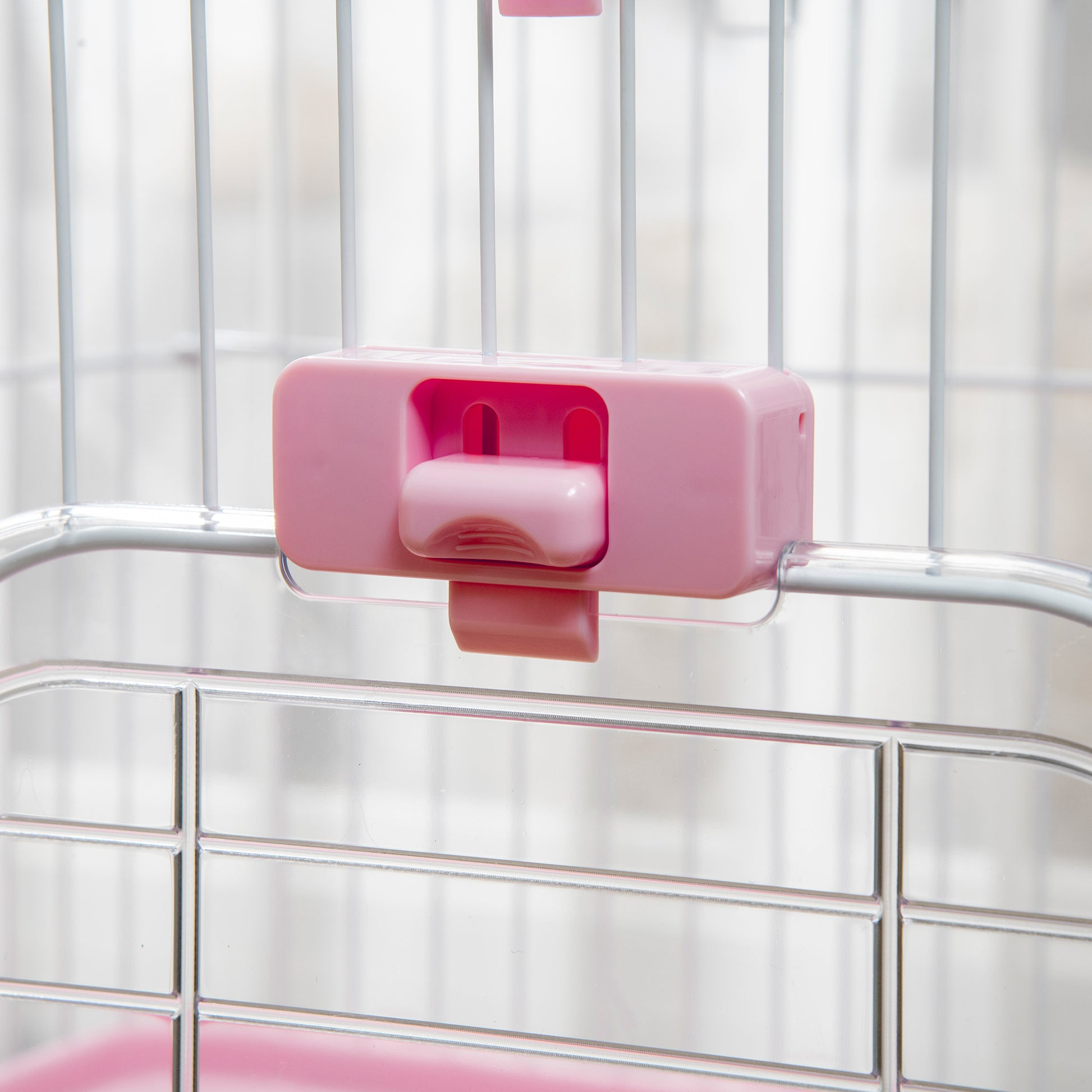 Pink plastic latch mechanism for a pet cage securely fastened to the wire bars