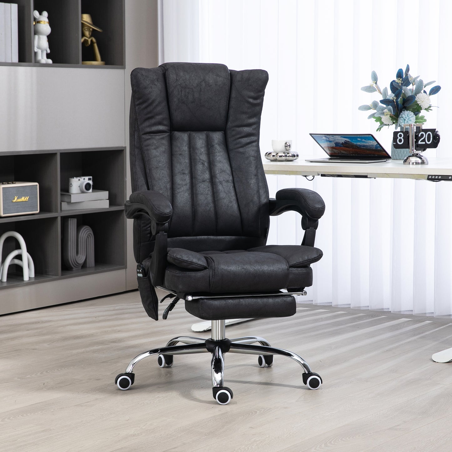Black executive office chair with padded headrest armrests and retractable footrest
