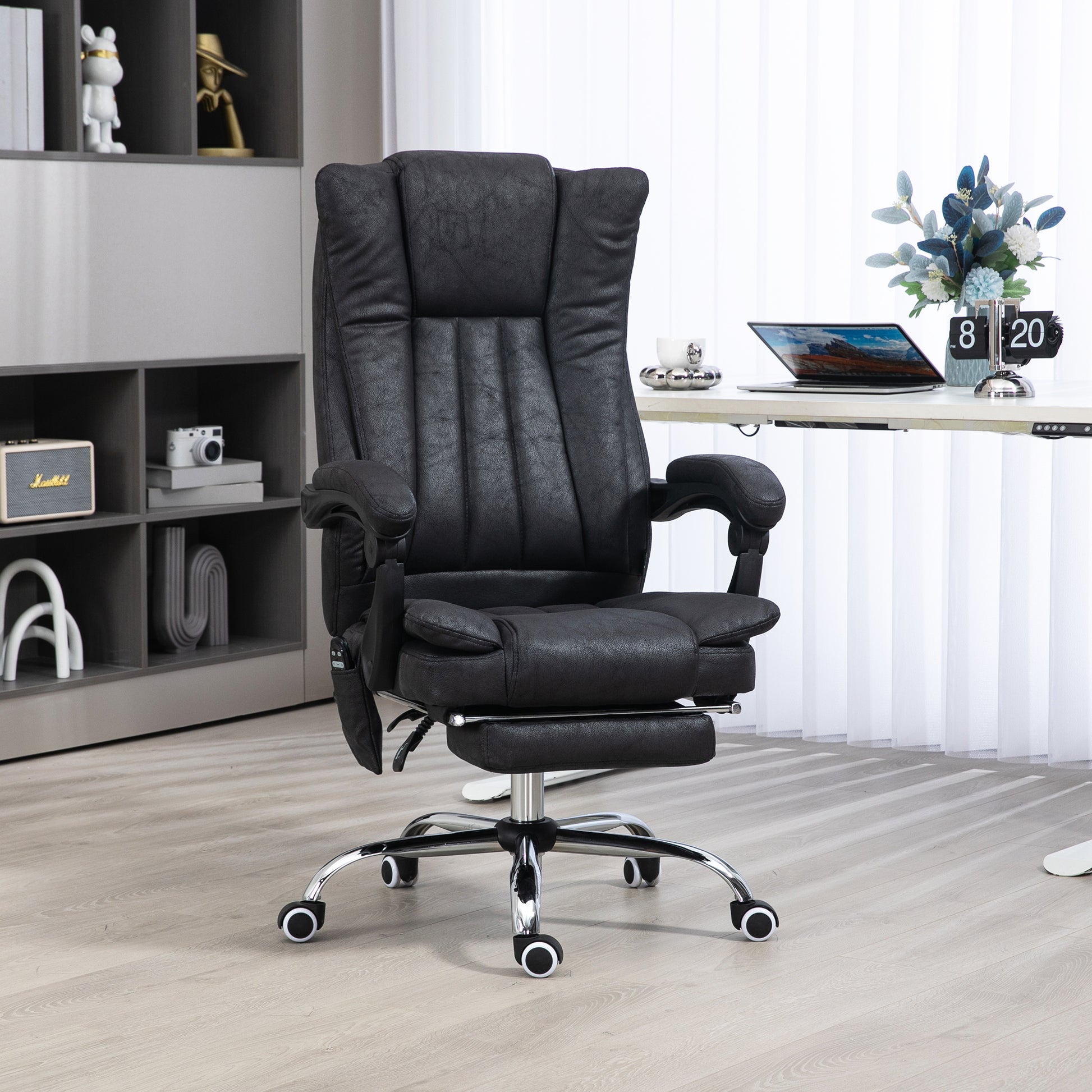 Black executive office chair with padded headrest armrests and retractable footrest