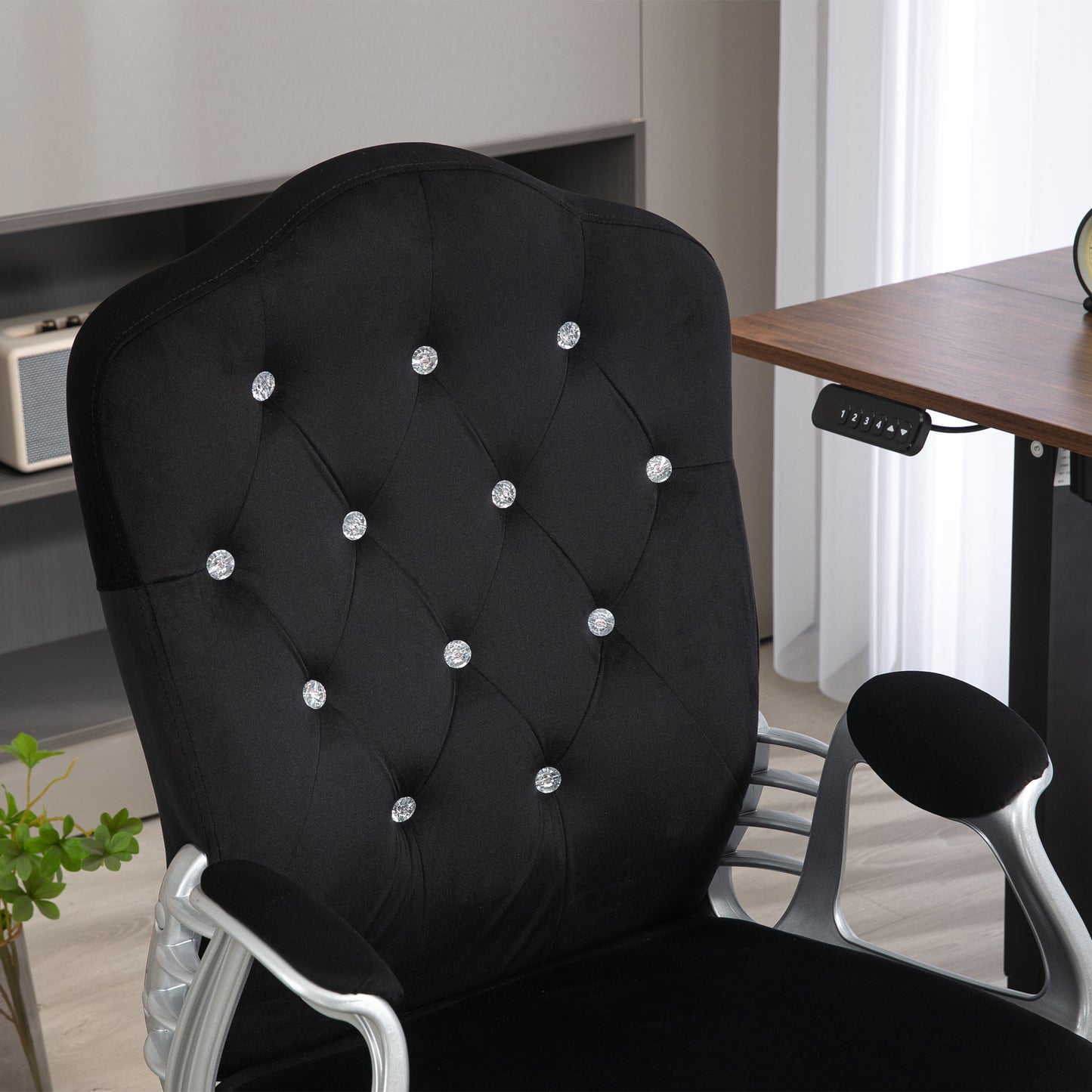 Black velvet executive chair with diamondlike tufting and silver arms for a regal look