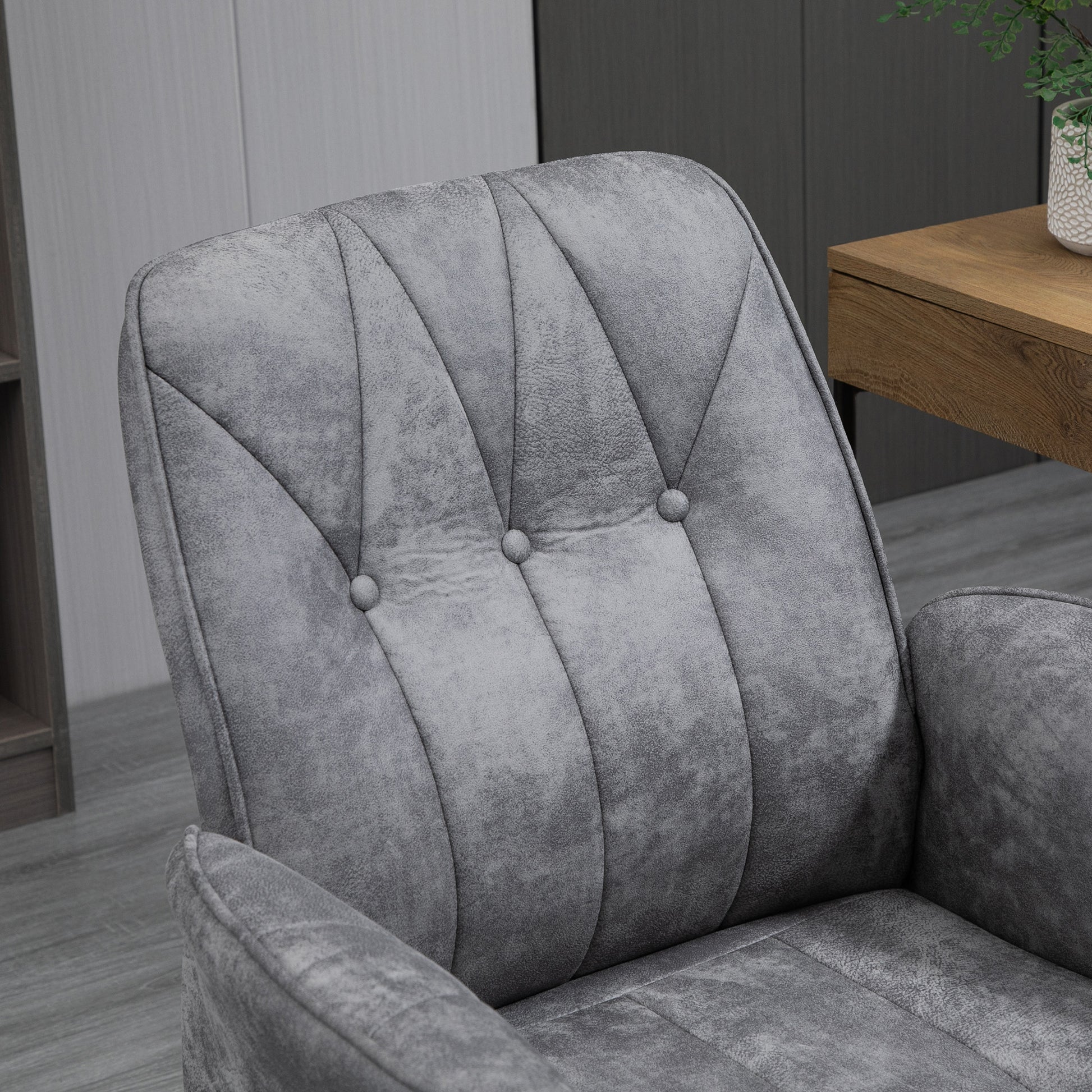 Closeup of a tufted grey velvet armchair accentuating its plush texture and elegant design