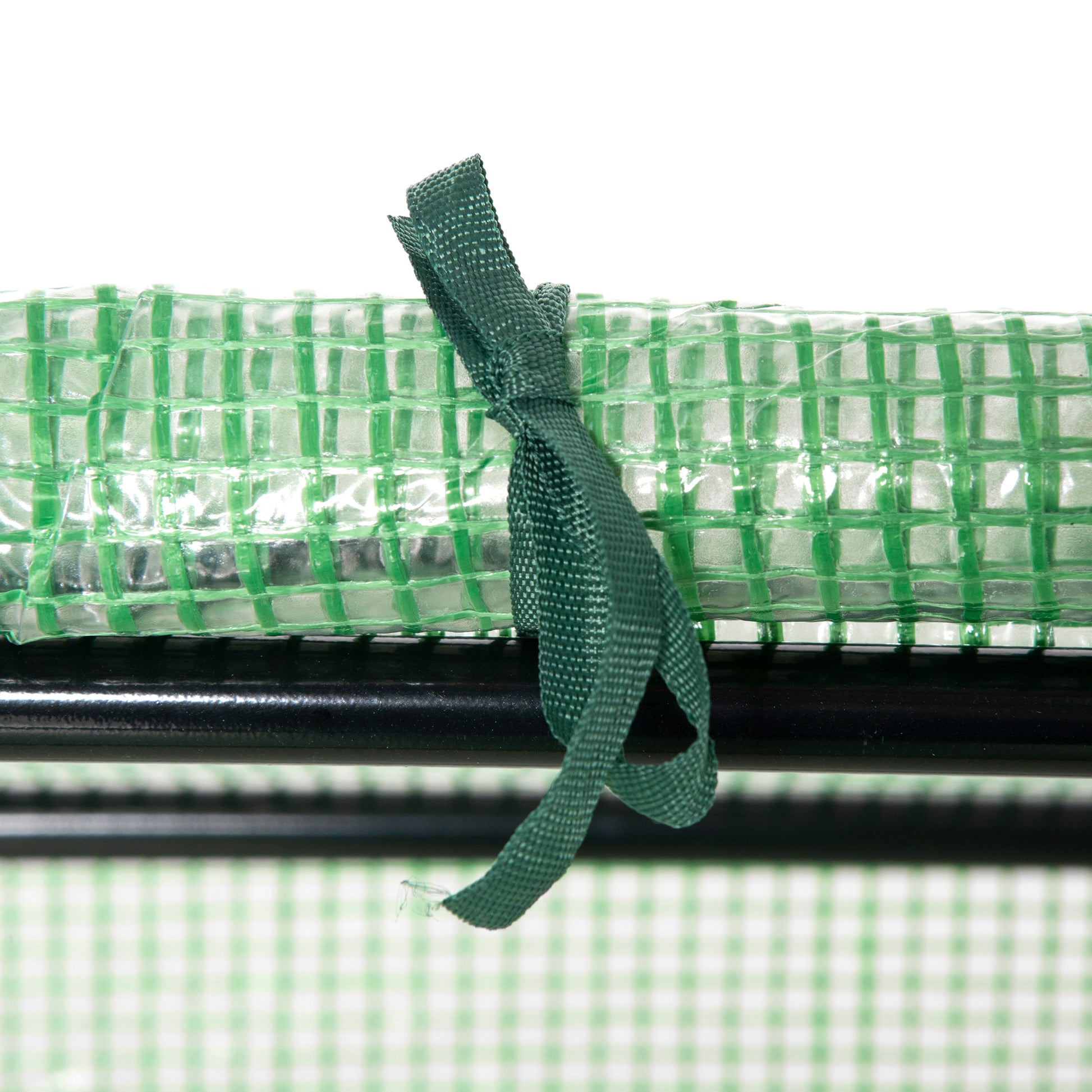 Green reinforced greenhouse film rolled and secured with a dark green fabric tie