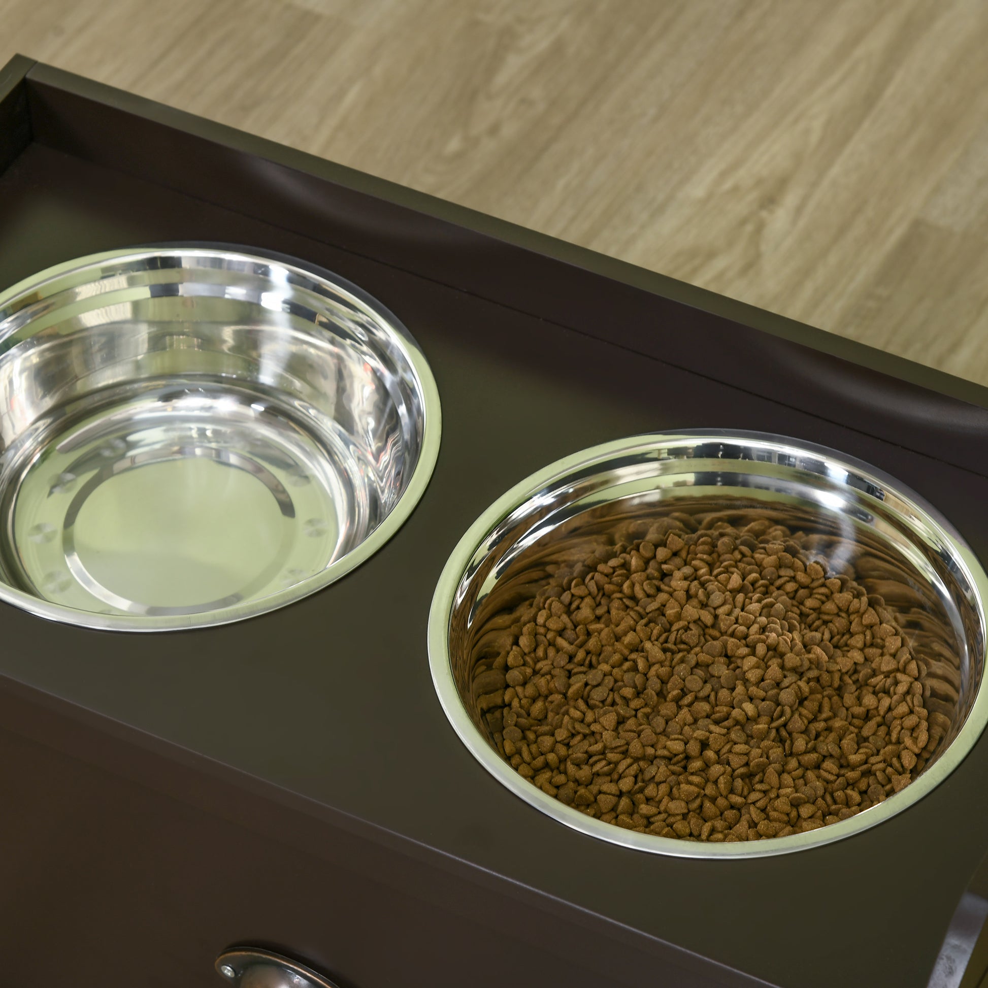 Dark wood raised dog feeder with two stainless steel bowls one filled with kibble
