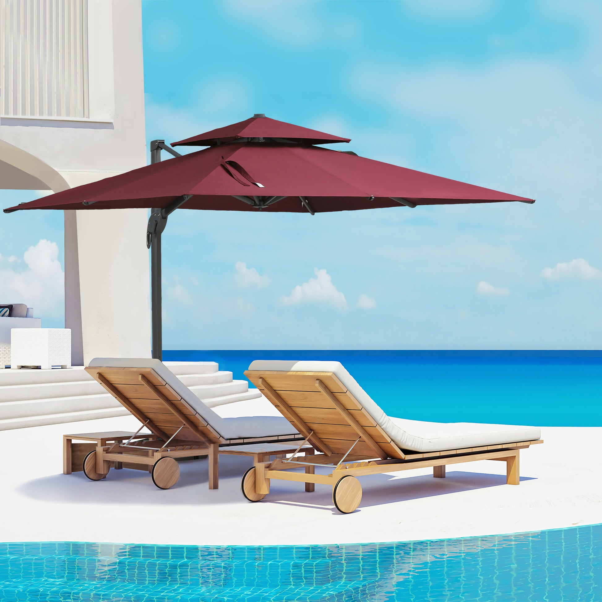 Two wooden chaise lounges with white cushions sit by a pool shaded by a large burgundy patio umbrella