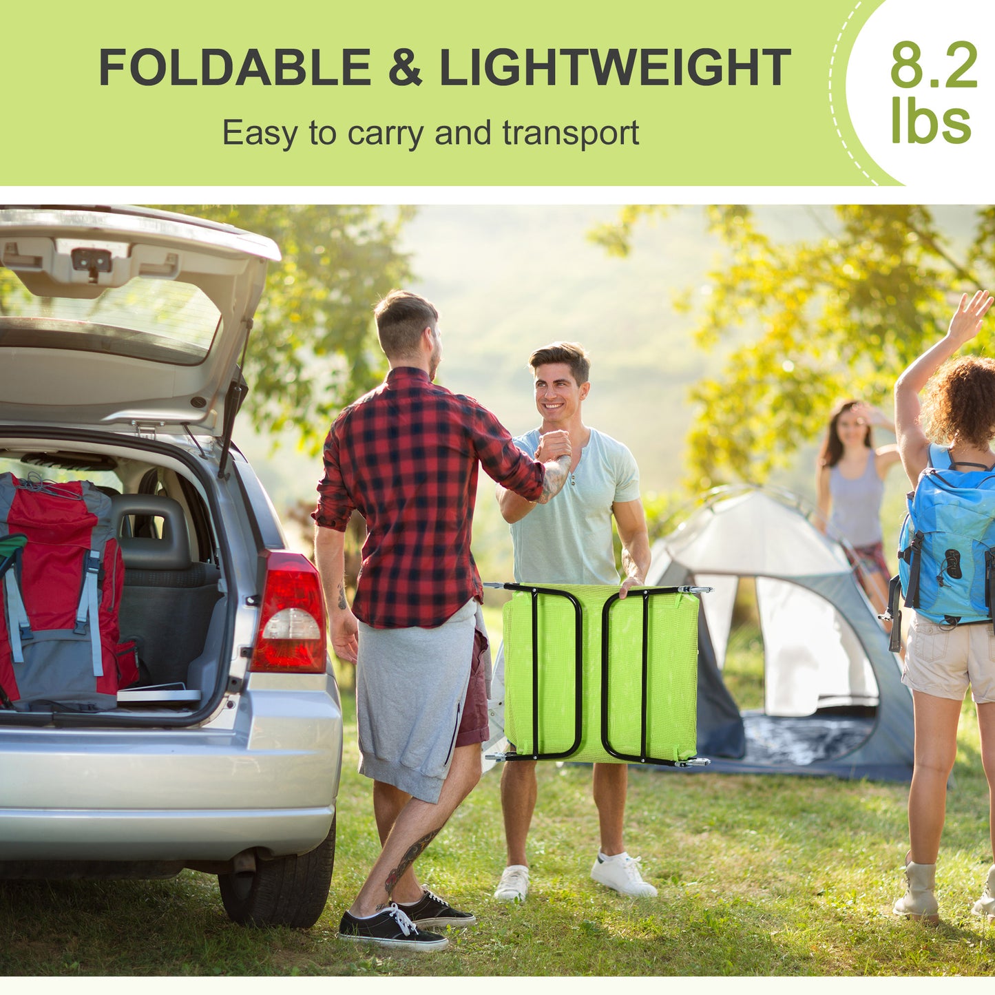 Two men carrying a green foldable camping chair with a car and tent in background