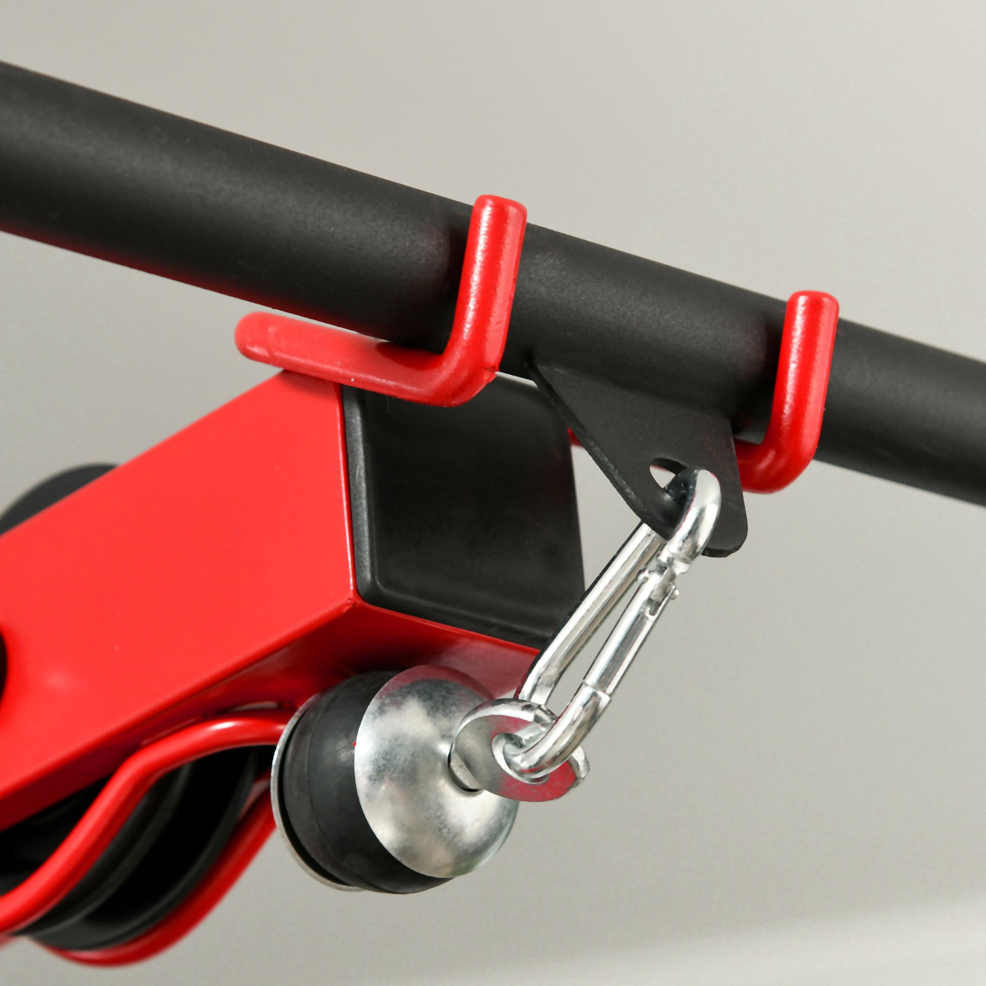 Red cable attachment with steel carabiner clip on a black bar