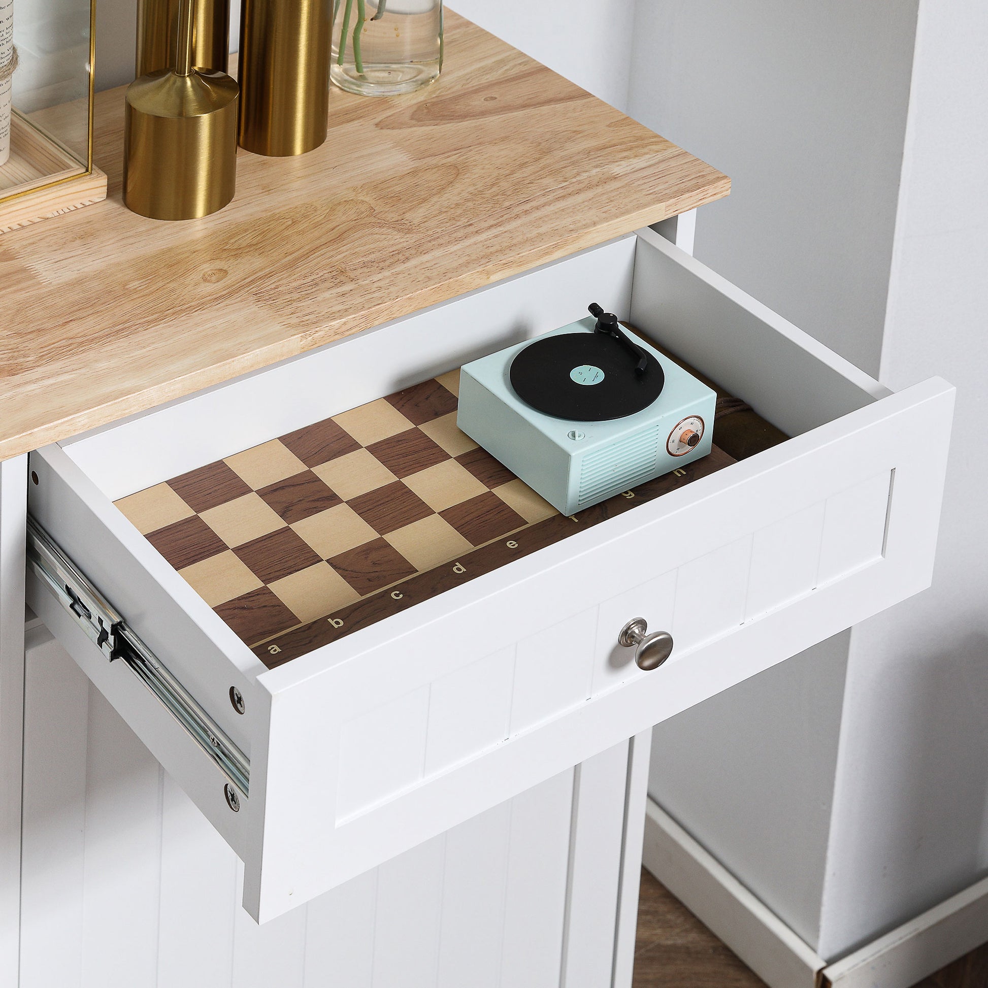 Open white drawer revealing a light blue vintage record player on a chessboard