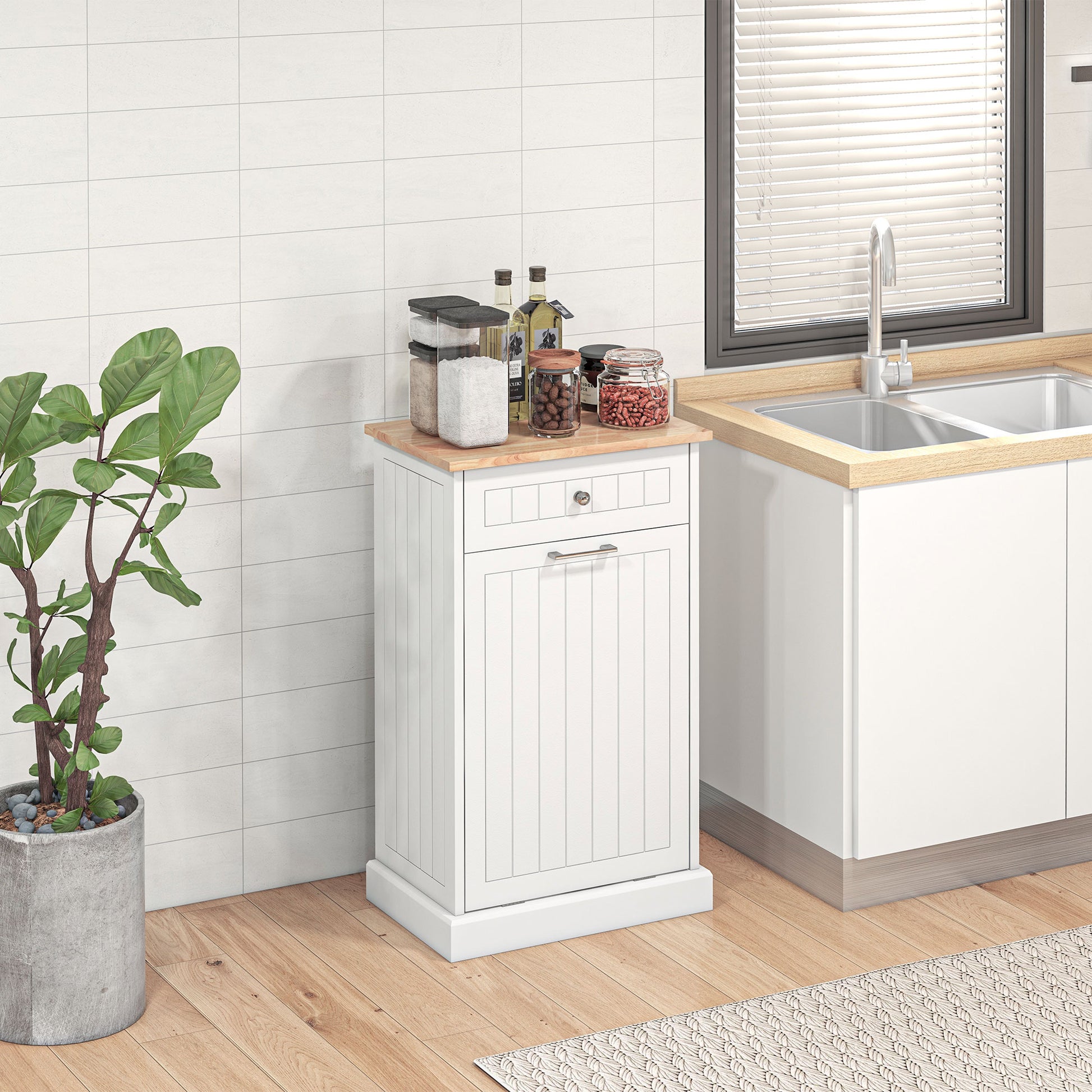 White kitchen cabinet with wooden top featuring a pullout trash bin compartment and storage drawer