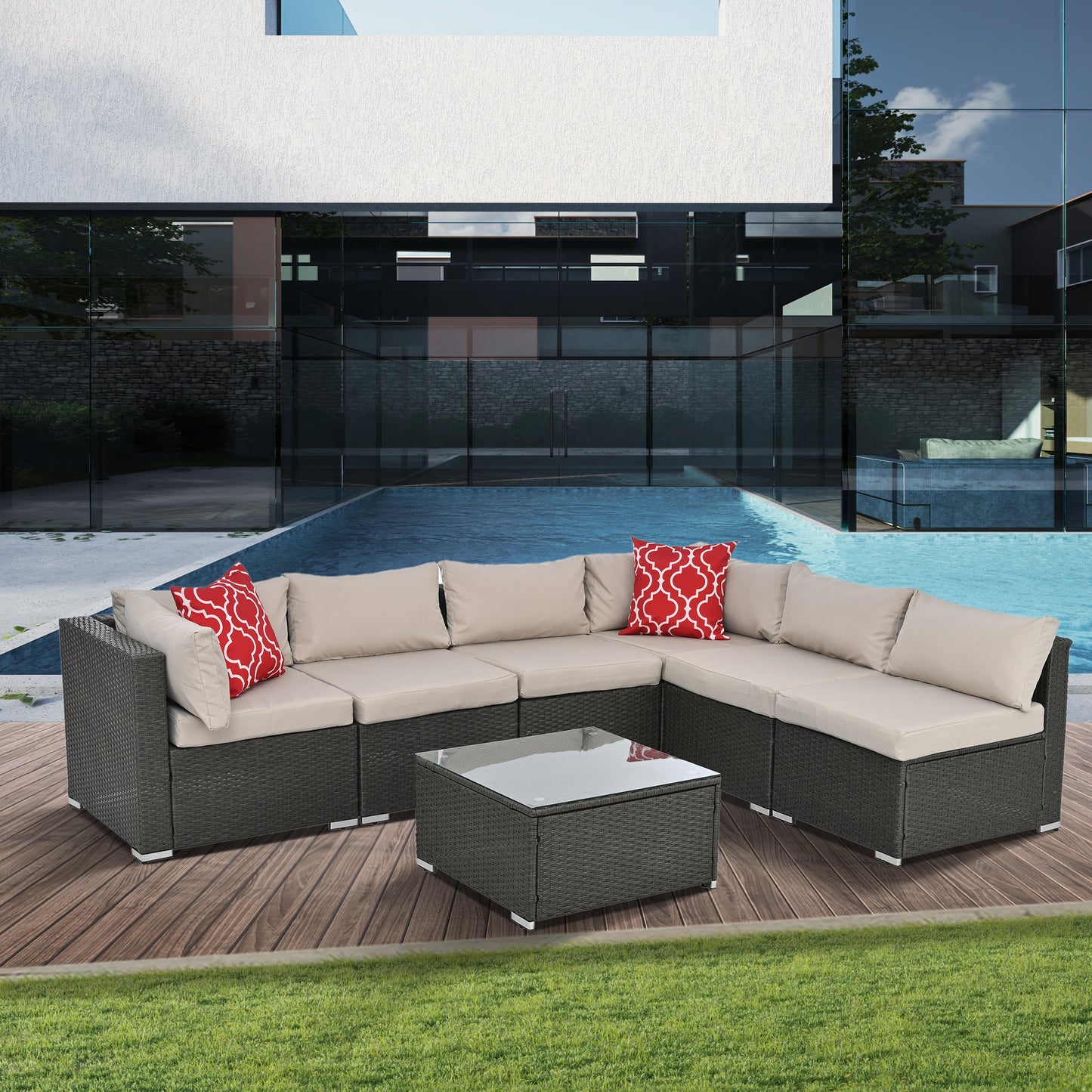 Dark gray wicker sectional patio furniture with beige cushions and red patterned pillows by a pool
