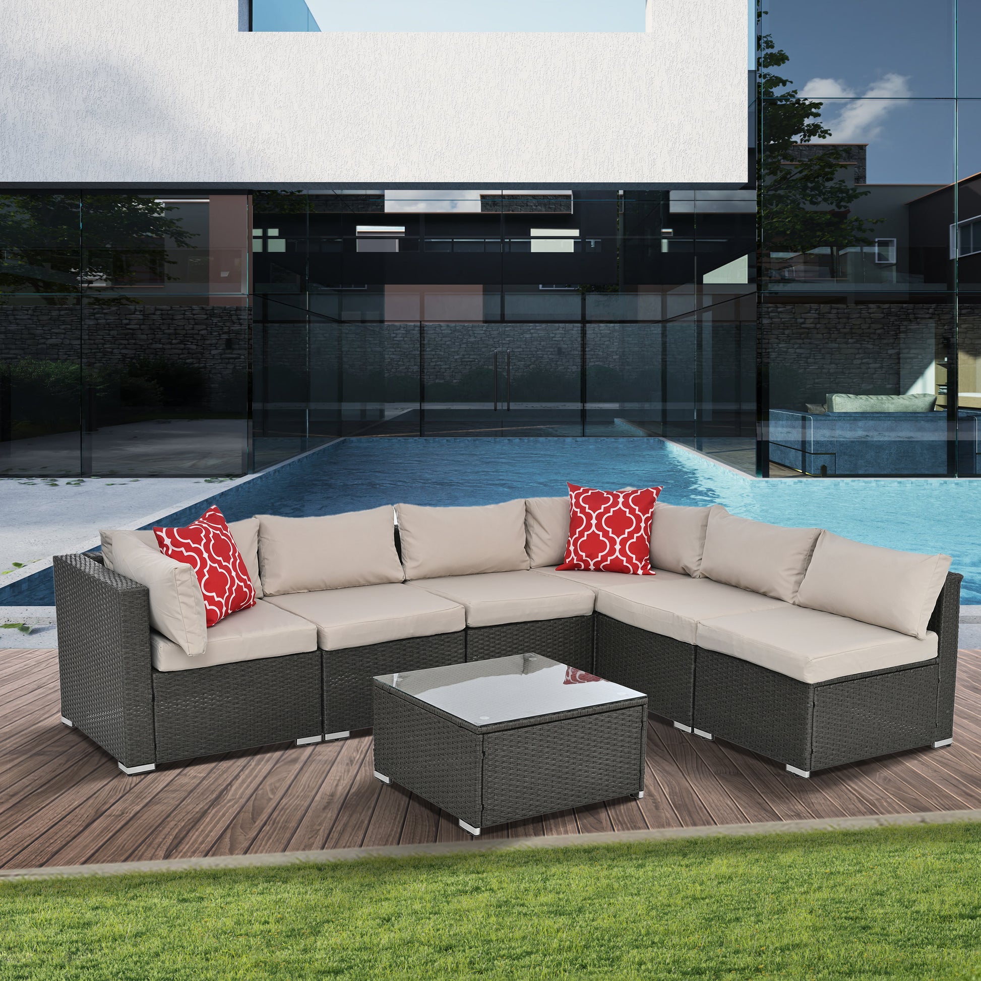 Dark gray wicker sectional patio furniture with beige cushions and red patterned pillows by a pool