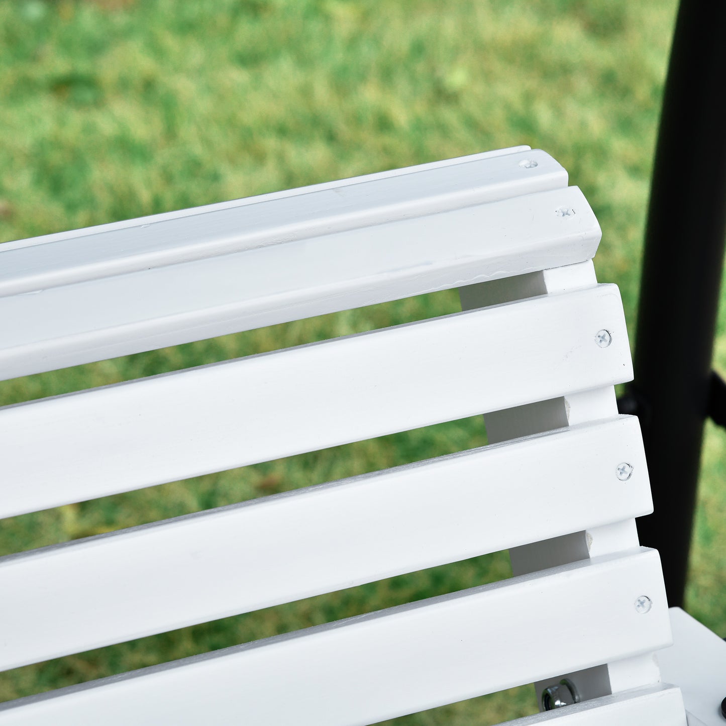 Closeup of white slat bench seating in a garden setting