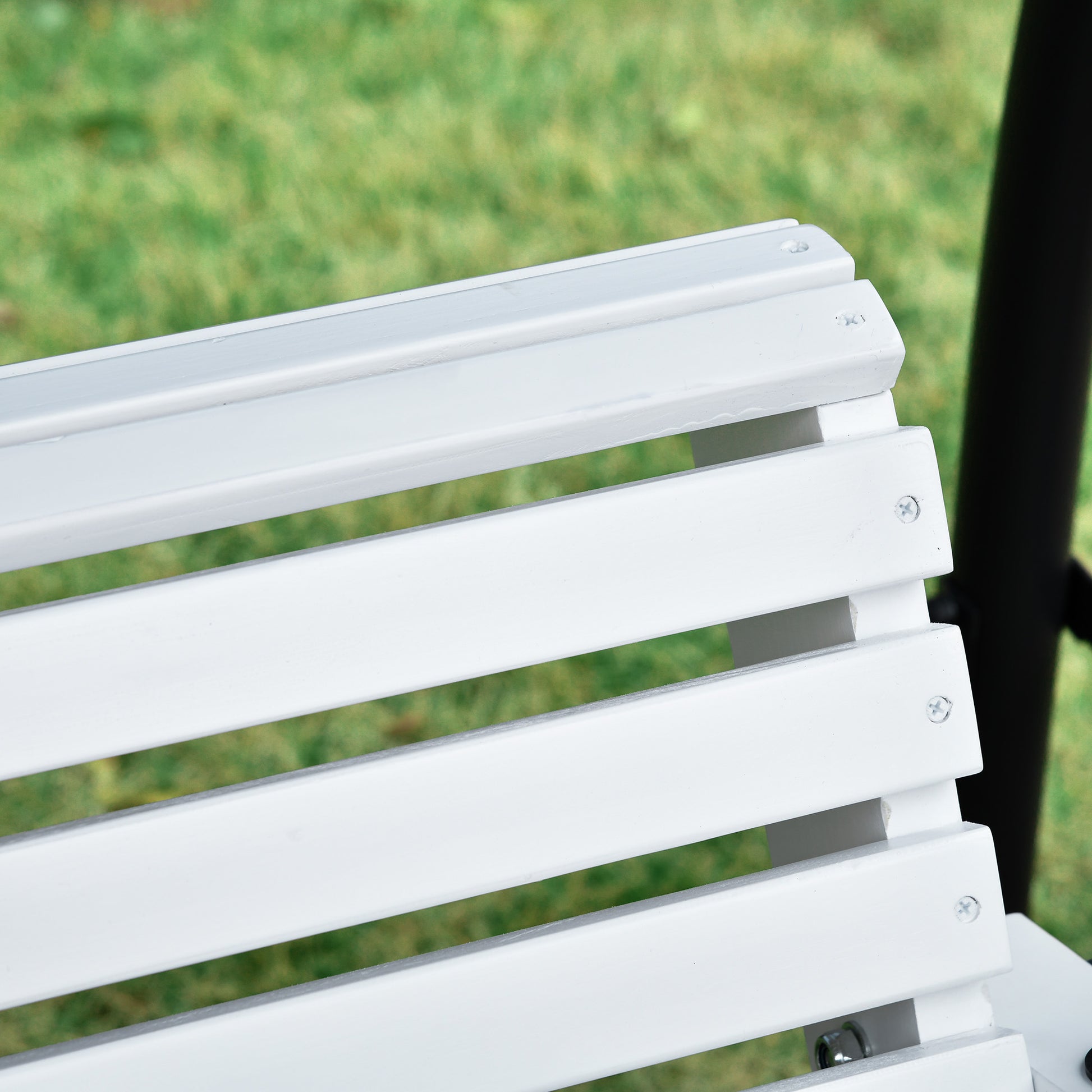 Closeup of white slat bench seating in a garden setting