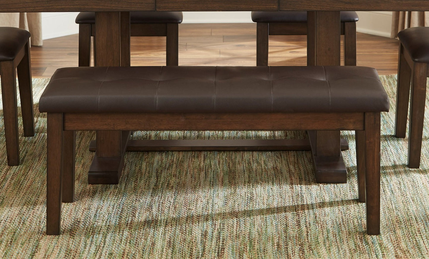 Tufted brown faux leather dining bench with dark wood frame