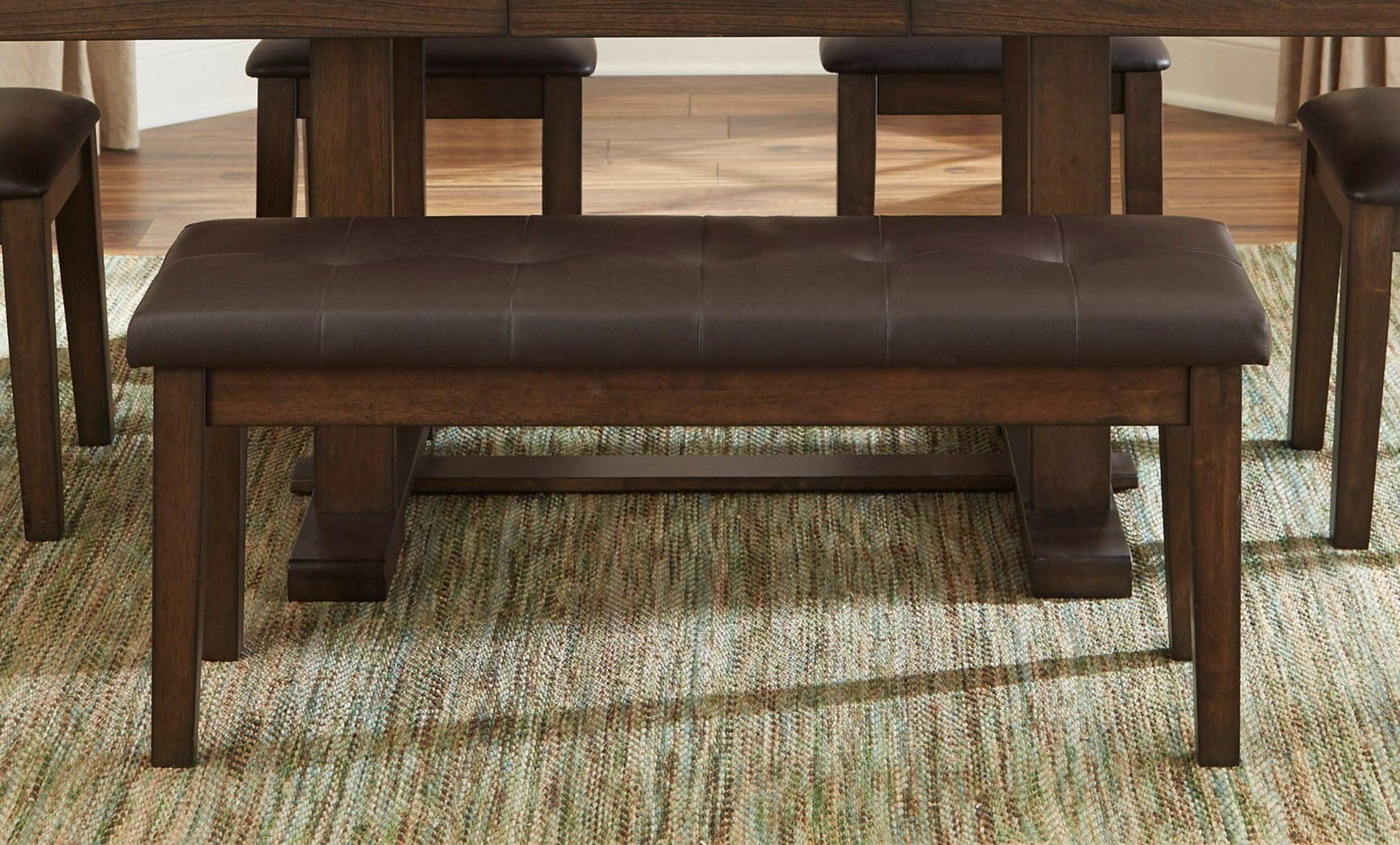 Tufted brown faux leather dining bench with dark wood frame