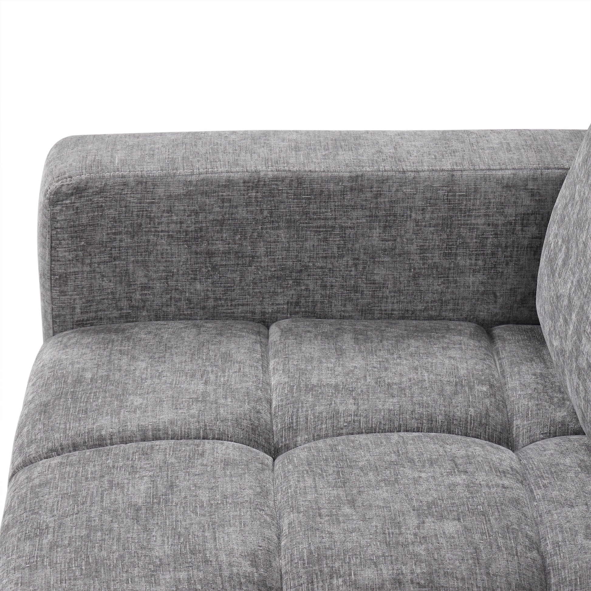 Closeup of a textured grey fabric sofa armrest and tufted seat cushions