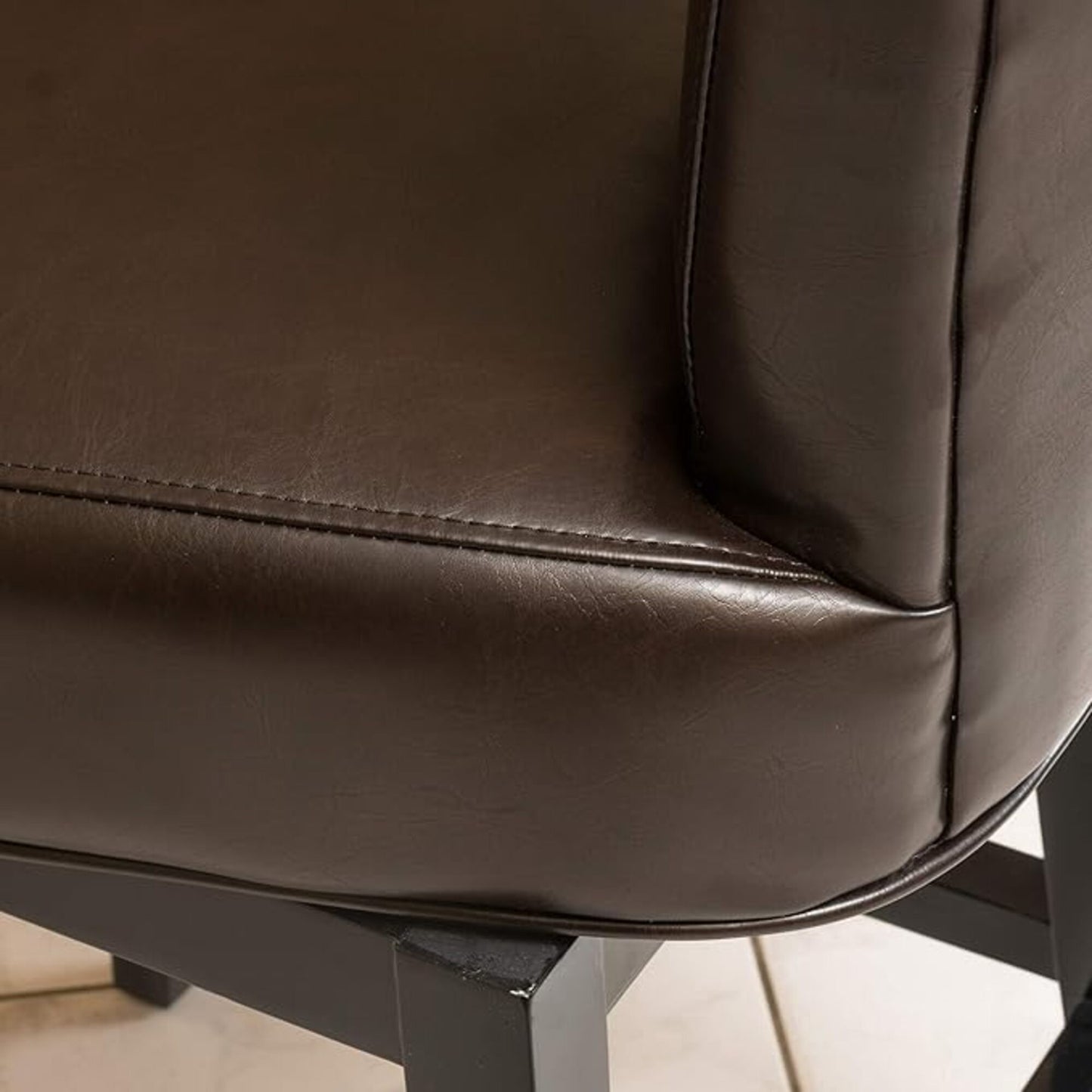 Dark brown faux leather bar stool seat with detailed stitching and black legs