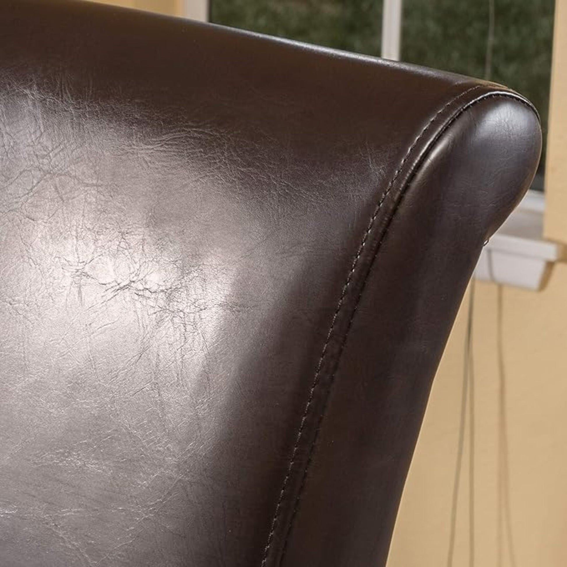 Rich dark brown faux leather chair back with subtle creasing and stitched seam detail