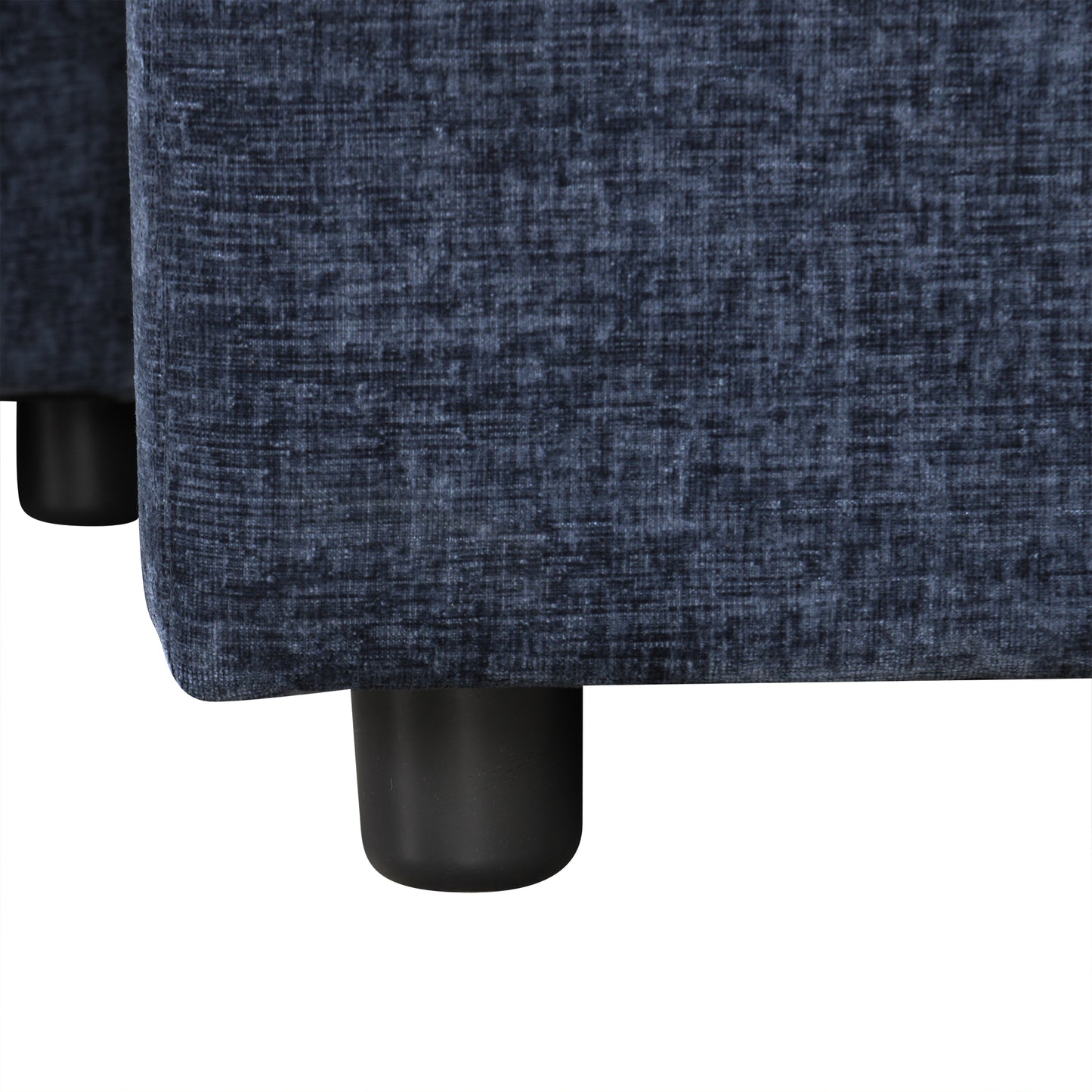Closeup of dark blue textured fabric on a sofa with black cylindrical feet