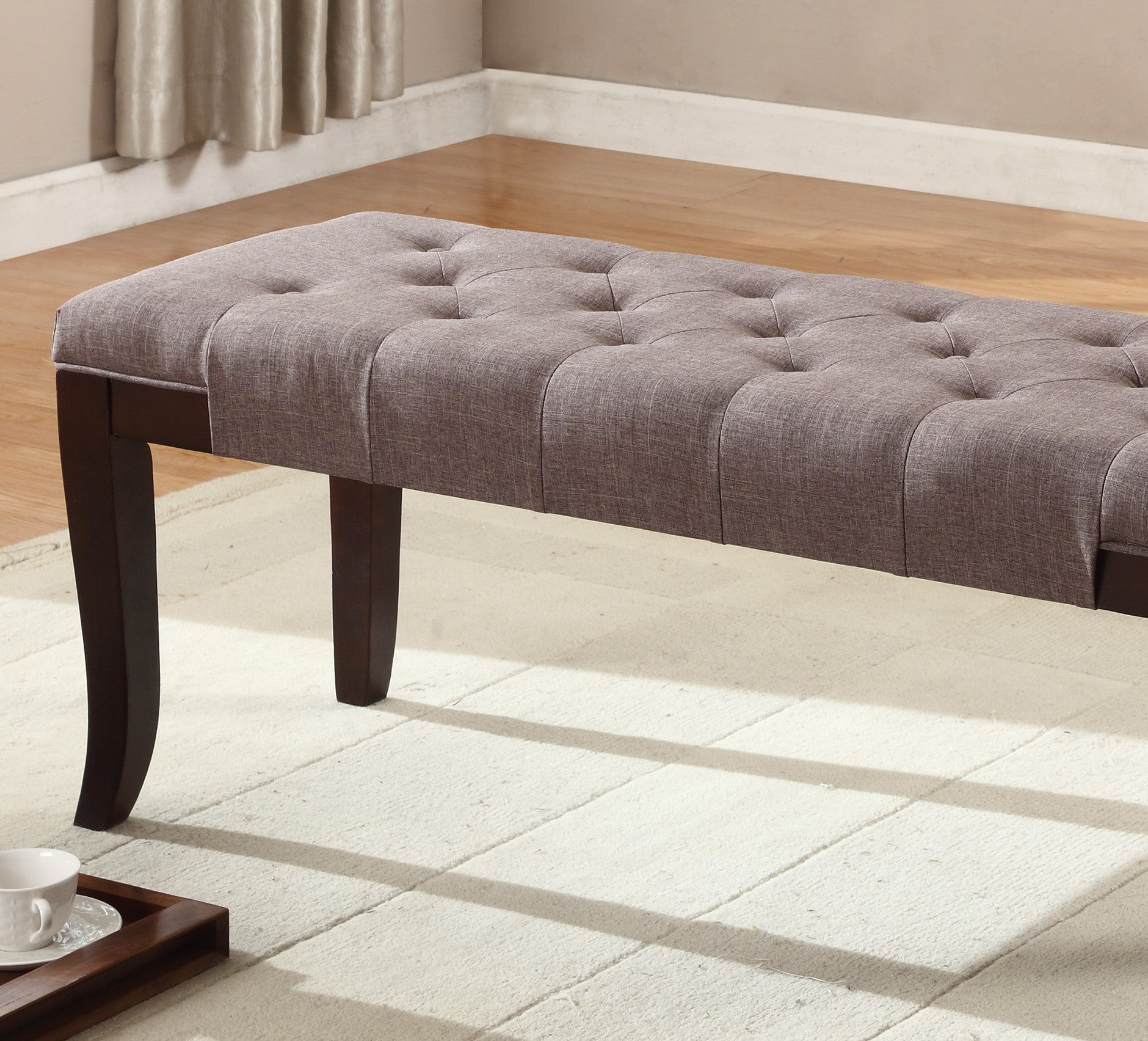 Tufted grey fabric storage bench with dark wood legs