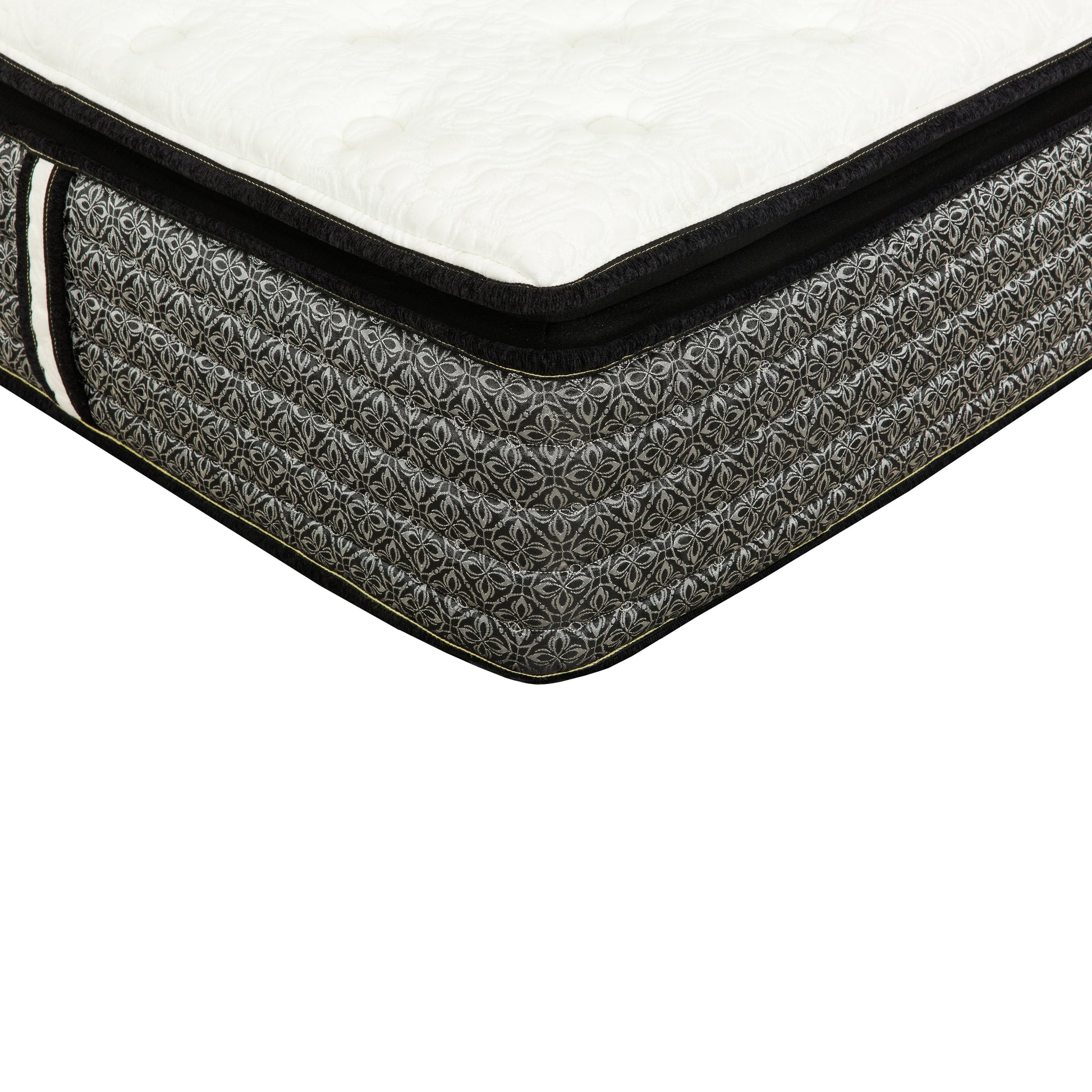 Closeup of a queen size mattress with a white quilted top and black sides featuring a silver floral pattern