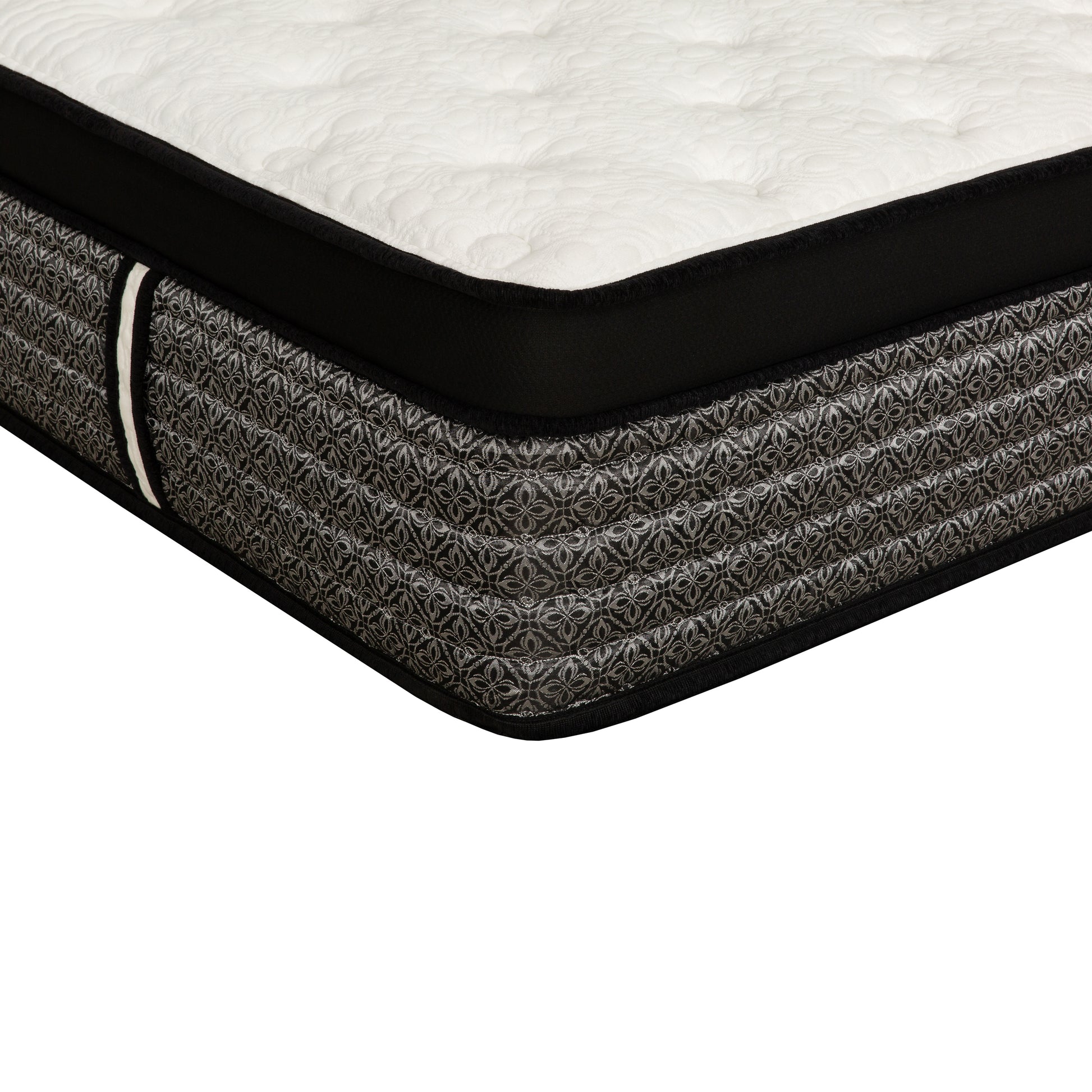 Closeup of a tufted white mattress with a black border and grey patterned side