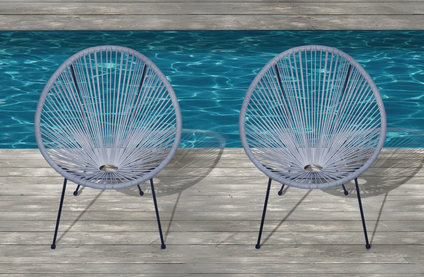Two gray Acapulco chairs with woven cord seats on a wooden deck by a pool