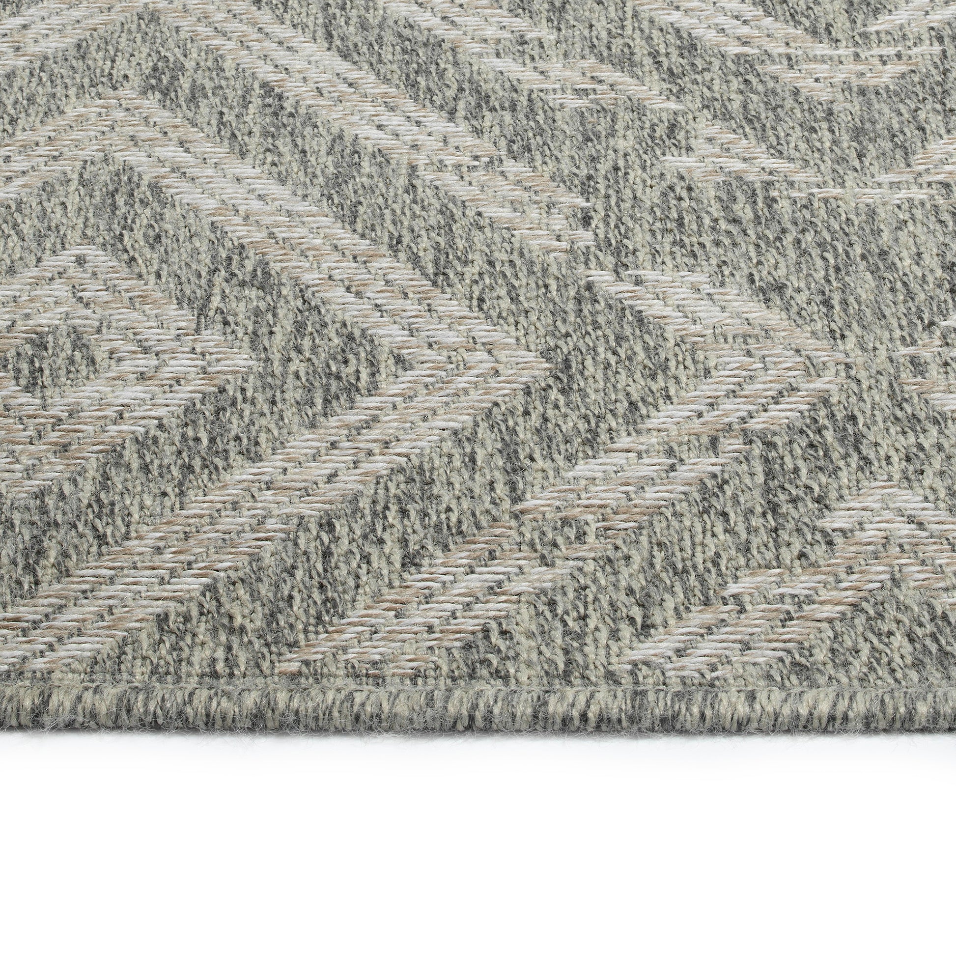 Closeup of a textured gray and beige chevron pattern rug suitable for modern decor