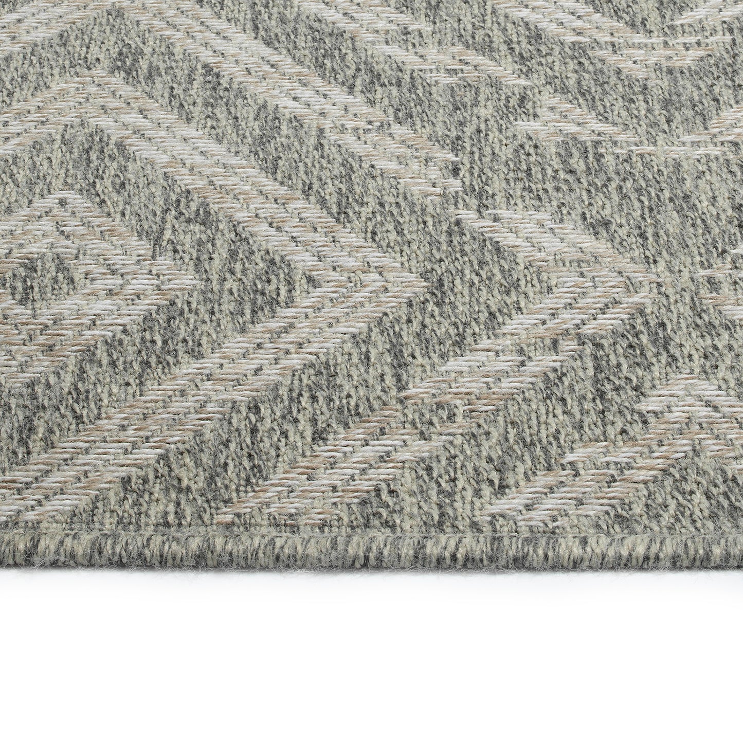 Closeup of a textured grey area rug with a woven chevron pattern and subtle beige accents suitable for living rooms