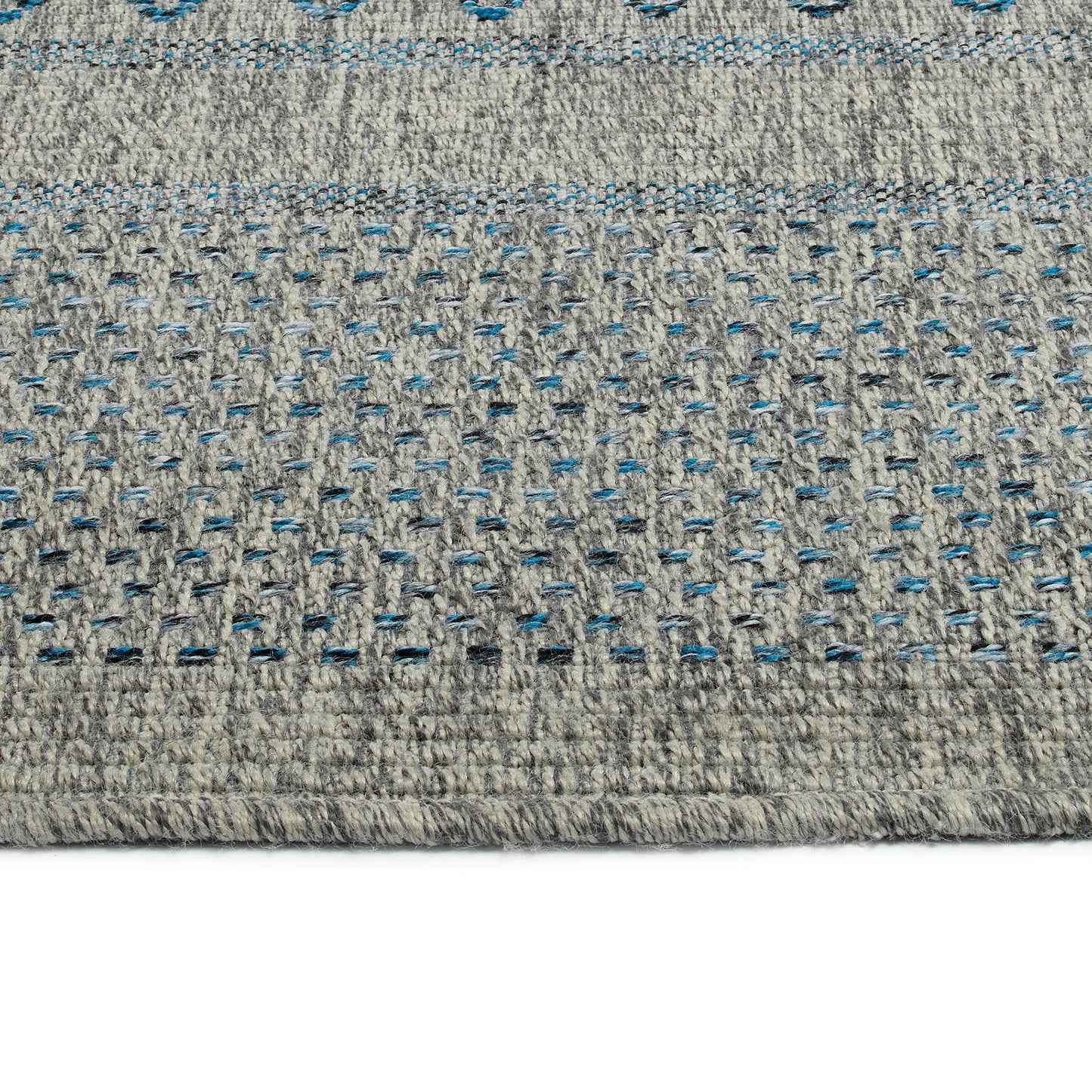 Closeup of textured grey rug with blue and black speckled pattern perfect for modern decor