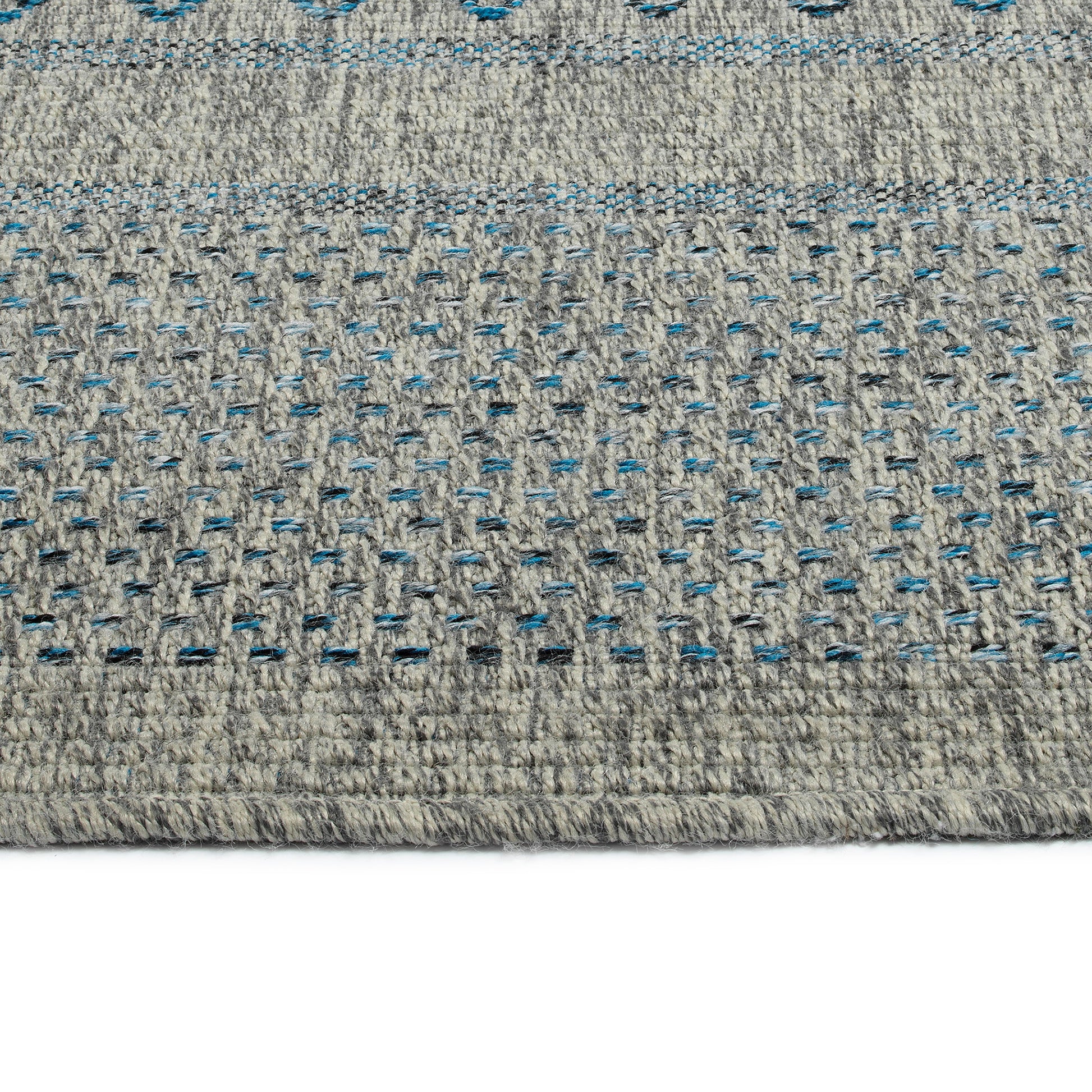 Closeup of textured grey rug with blue and black speckled pattern perfect for modern decor