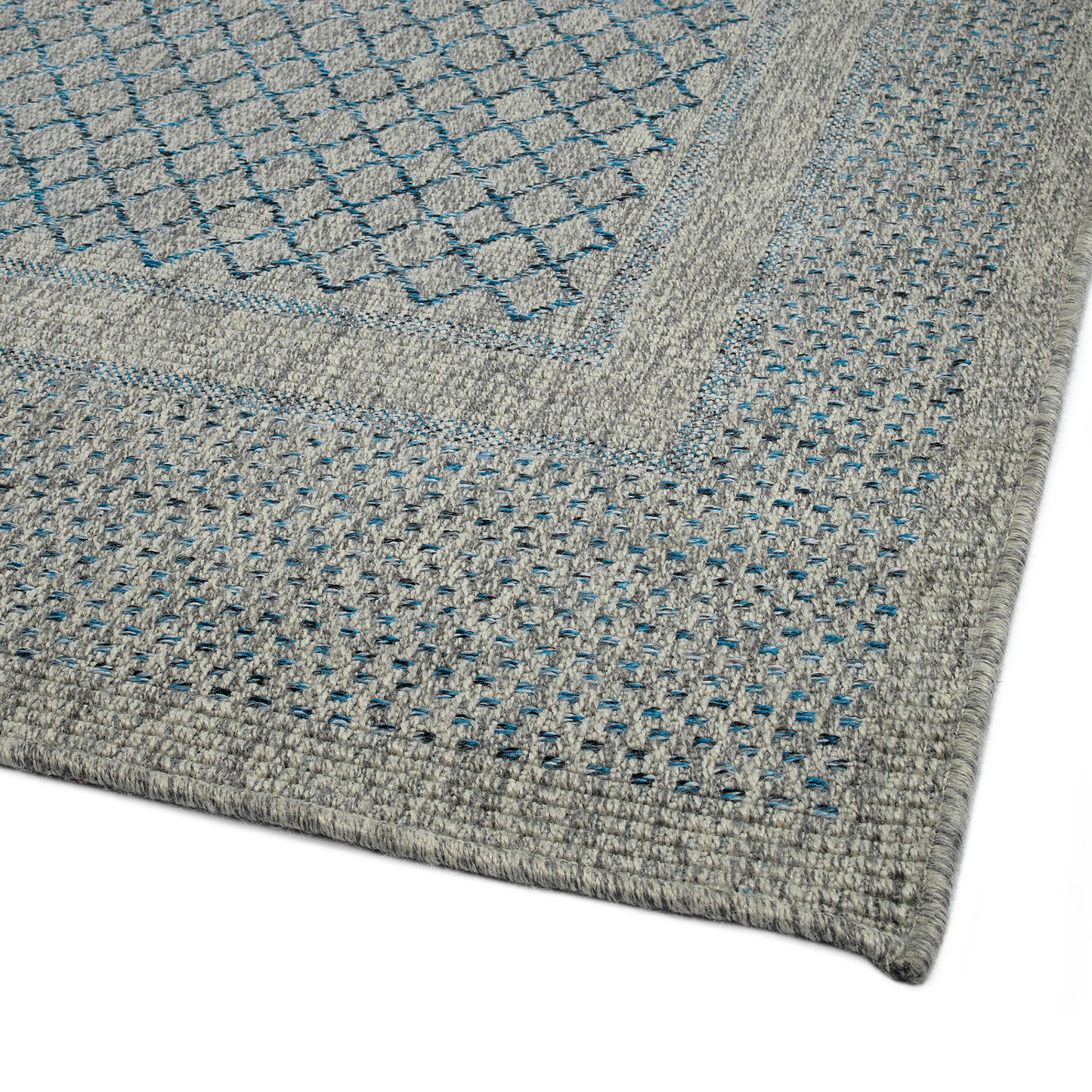Closeup of a grey braided rug with a diamond pattern in blue and black accents