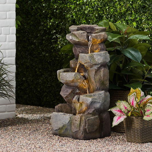 Multitiered faux rock outdoor fountain with cascading water and builtin LED lights