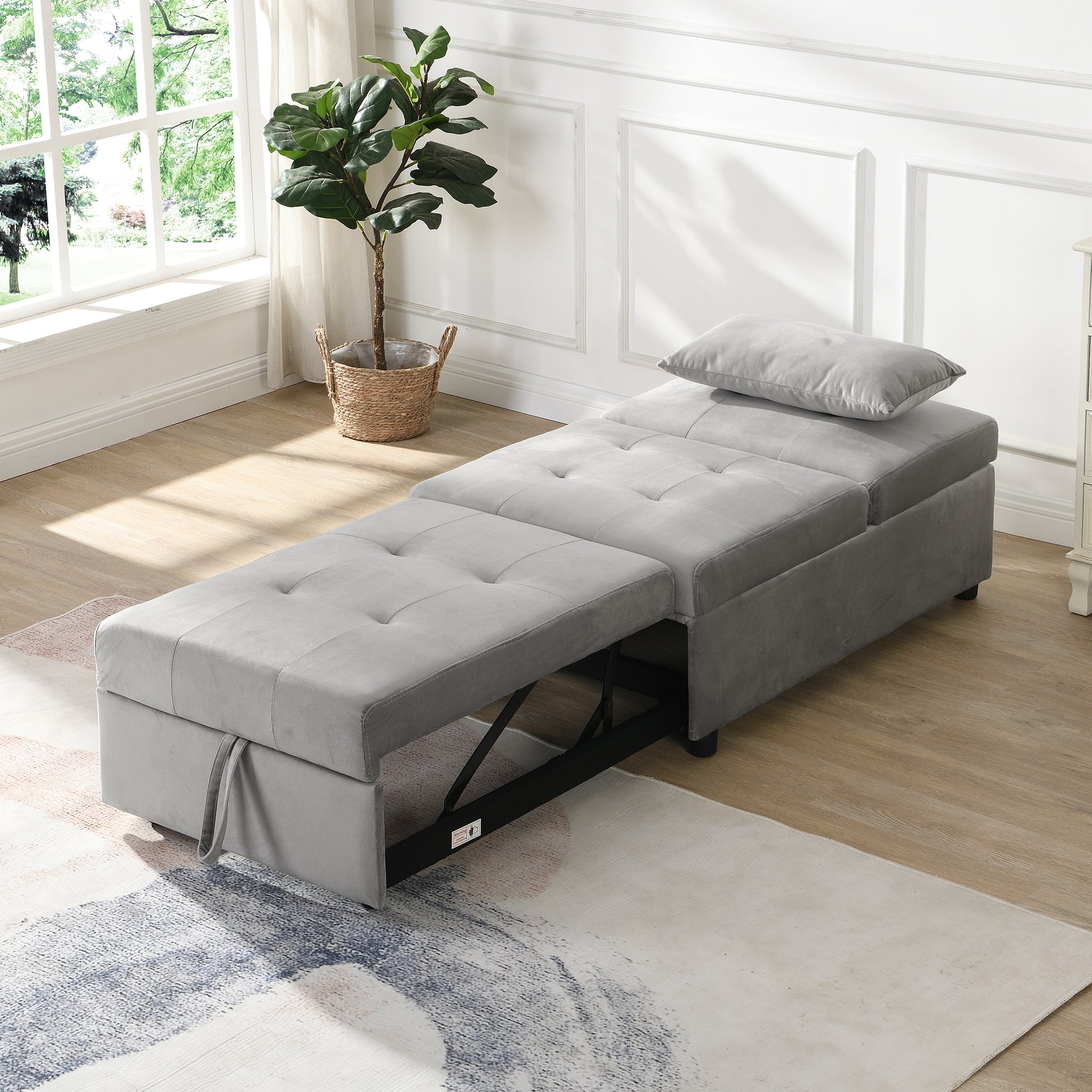 Grey upholstered sleeper chair with extended ottoman and tufted cushions