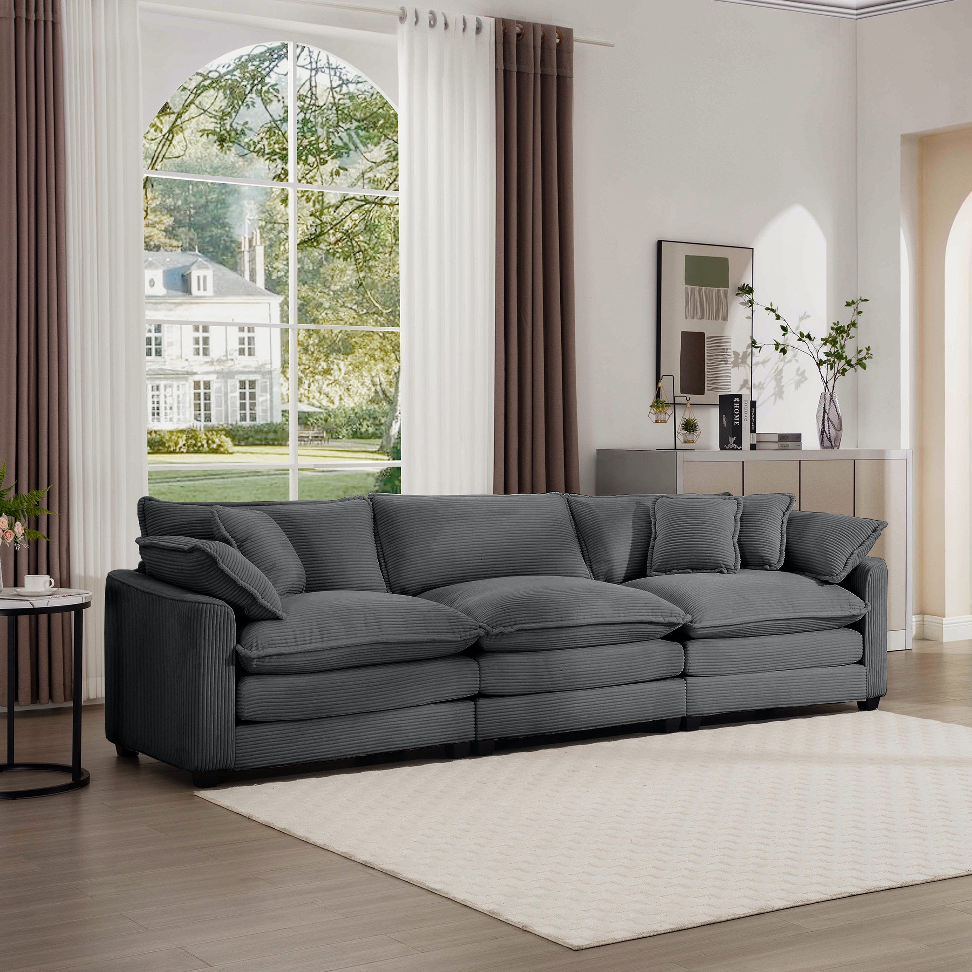 Plush grey corduroy sofa with deep seats and multiple cushions perfect for a cozy living room