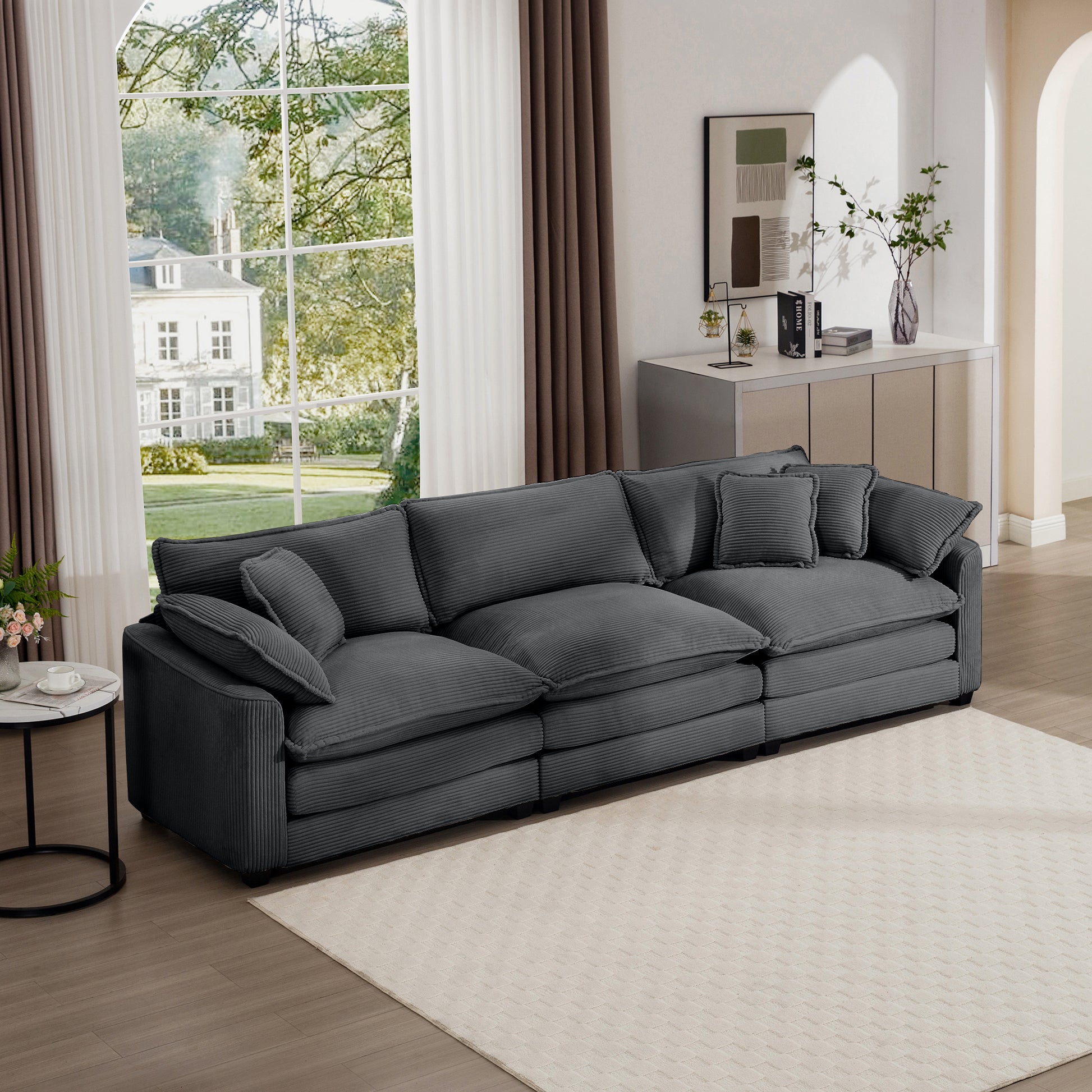 Plush dark gray corduroy sectional sofa with deep seats and multiple throw pillows