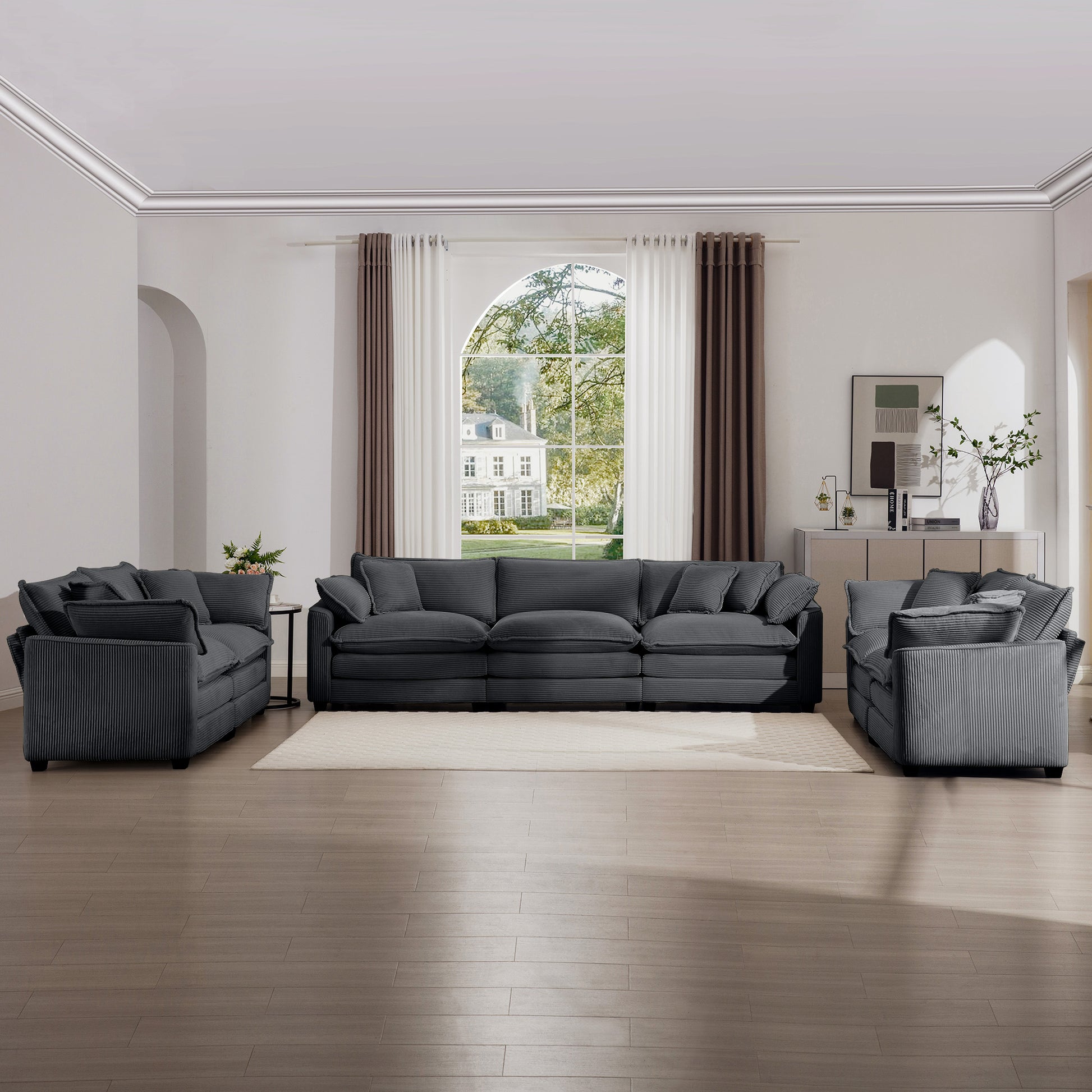 Dark grey corduroy sectional sofa with plush cushions and matching armchairs