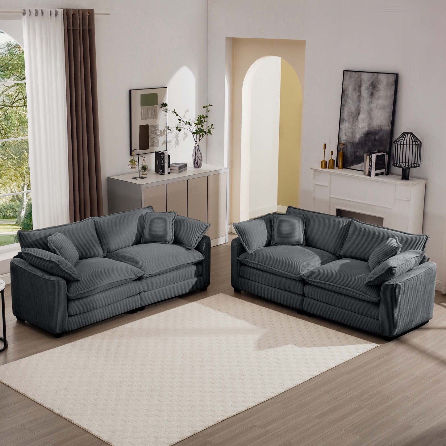 Two grey corduroy sofas with plush cushions arranged in a living room