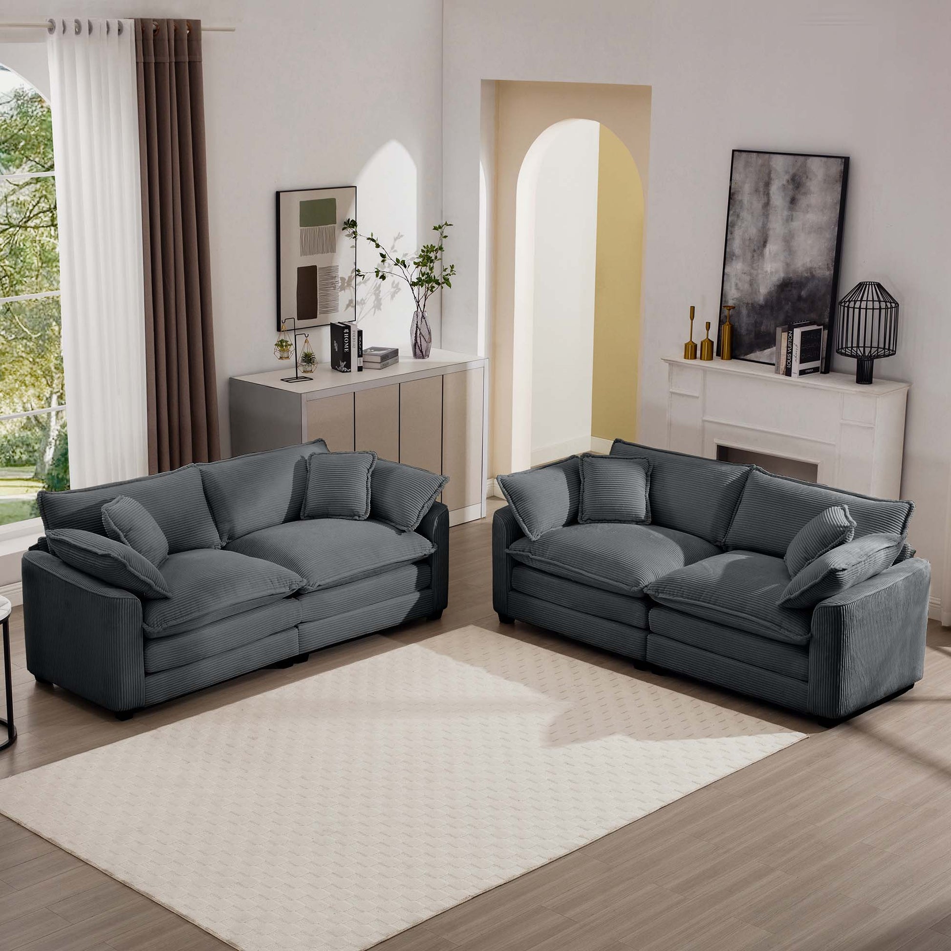 Two grey corduroy sofas with plush cushions arranged in a living room