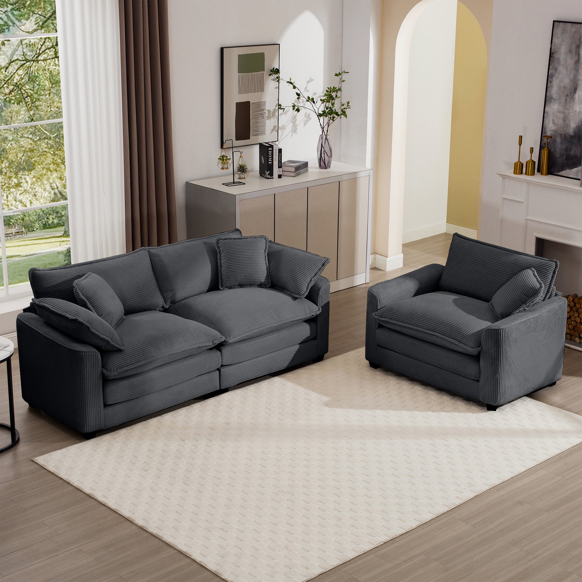Charcoal corduroy sofa with plush cushions and matching armchair on a cream rug