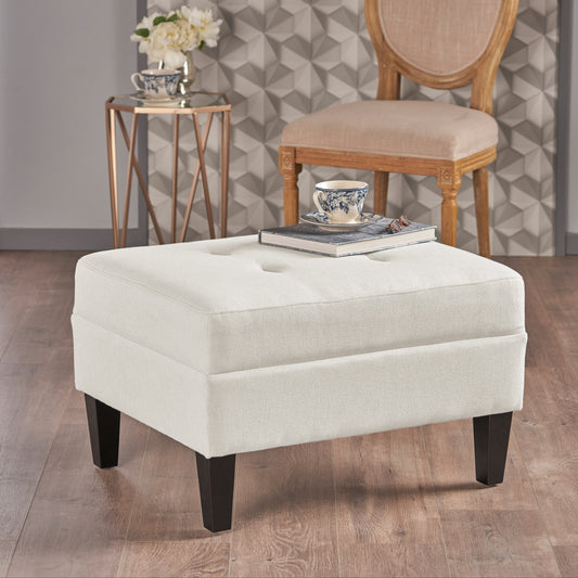 Square ivory upholstered ottoman with dark wooden legs featuring tufted top detail for living room