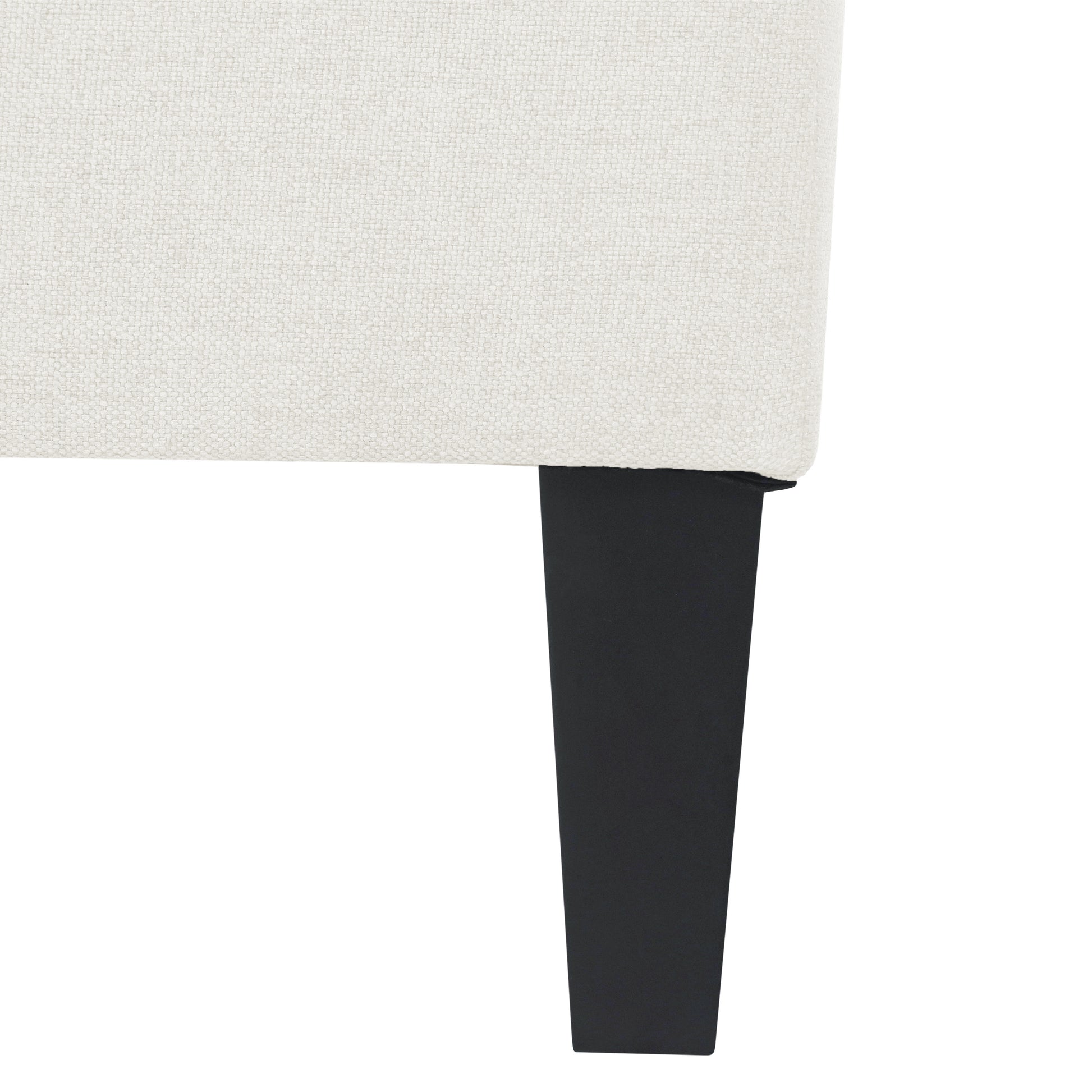 Closeup of textured offwhite fabric on a modern sofa leg in black