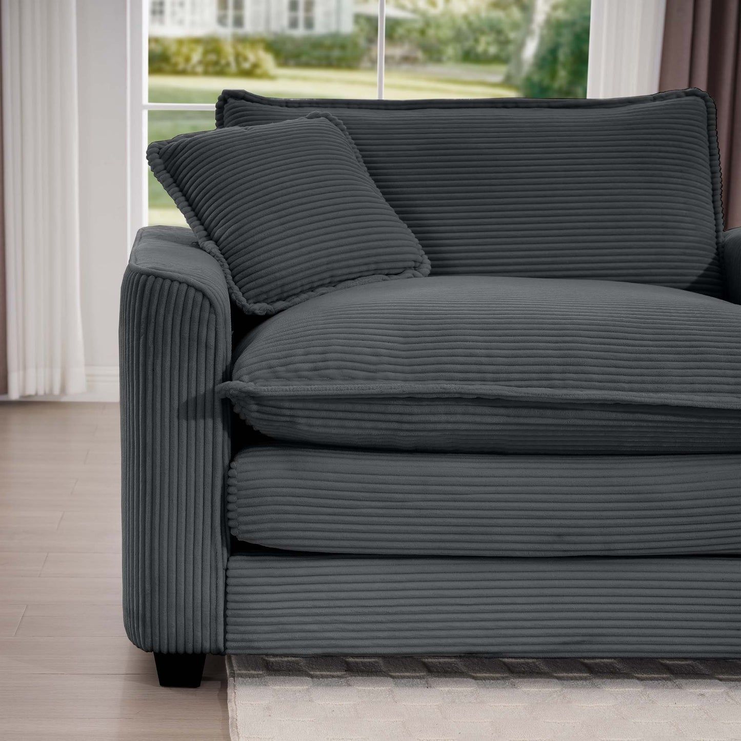 Dark gray corduroy sofa with plush cushions and a throw pillow