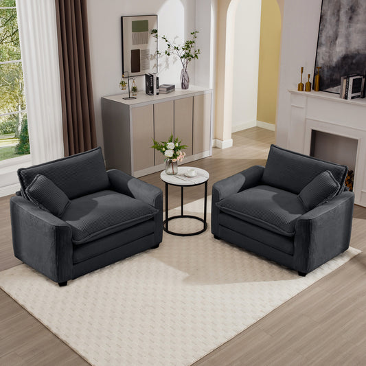 Two dark grey corduroy armchairs with plush cushions and small accent pillows