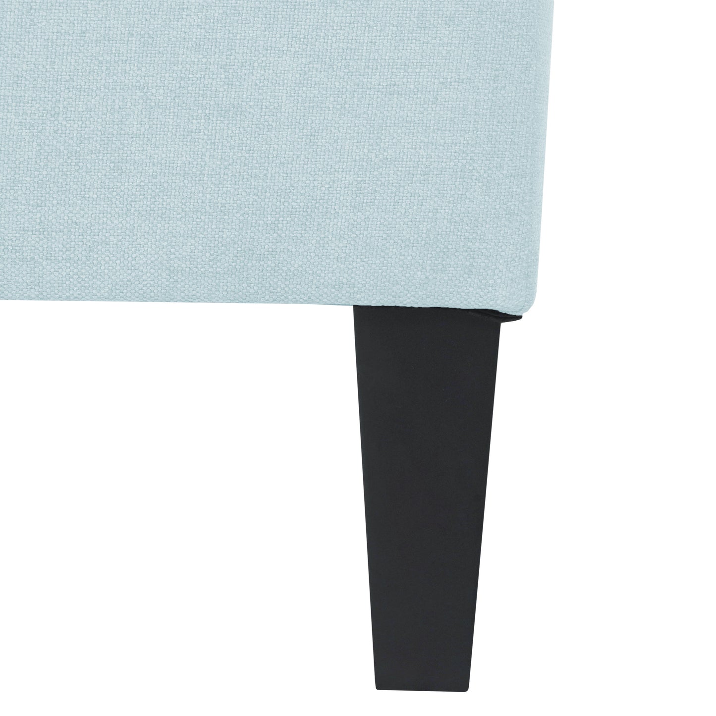 Closeup of a pale blue textured fabric sofa armrest with a black tapered leg